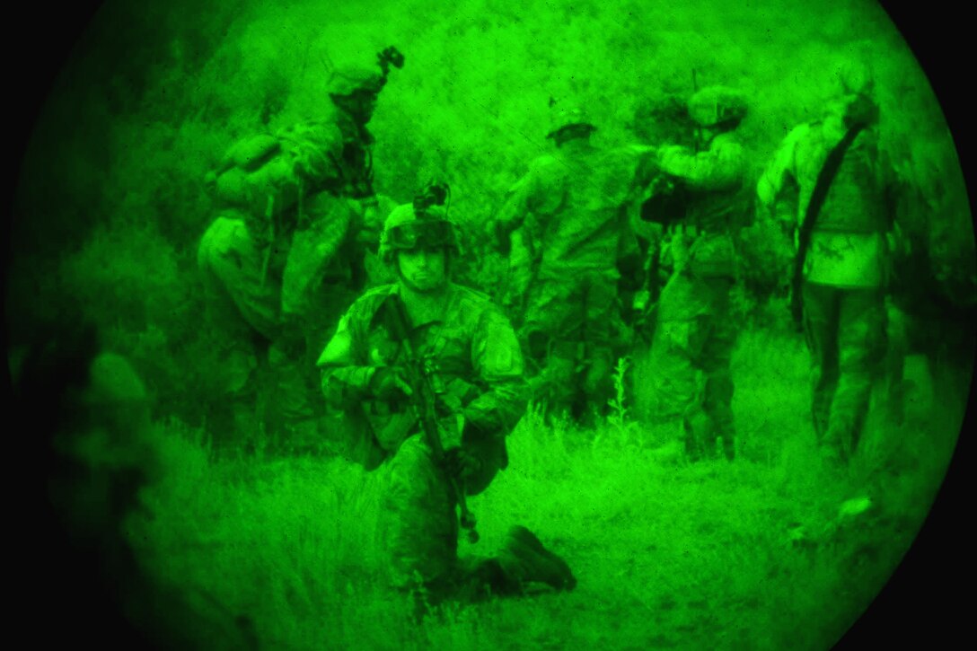 As seen through a night-vision lens, a U.S. soldier provides security while team members prepare to move mock casualties during Bayonet-Minotaur Exercise 2017 in Thessaloniki, Greece, May 17, 2017. Army photo by Graigg Faggionato