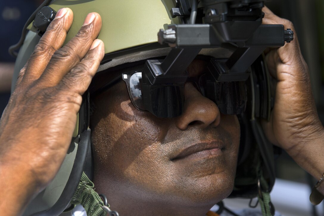 Journalist Aryankalayil Babu tries on an Army aviation helmet with a heads-up display during DoD Lab Day at the Pentagon, May 18, 2017. DoD photo by EJ Hersom