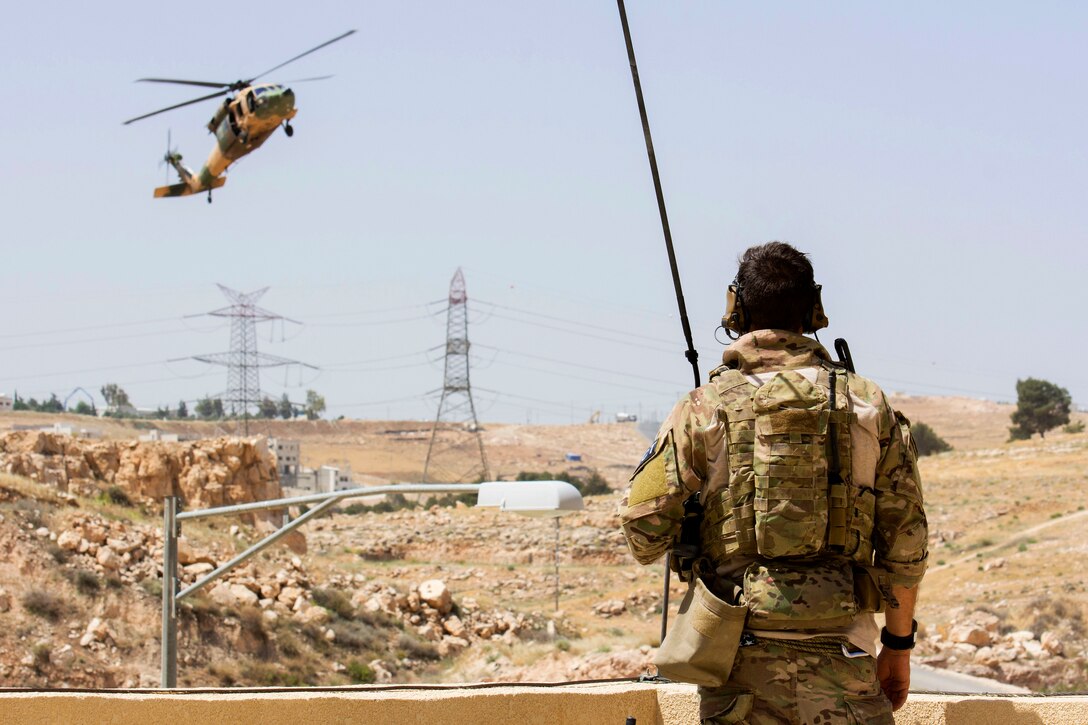 An airman communicates with Jordanian pilots in a UH-60 helicopter as it makes a landing approach at the King Abdullah II Special Operations Training Center during exercise Eager Lion 2017 in Amman, Jordan, May 11, 2017. The airman is a Combat Controller assigned to the 23rd Special Tactics Squadron. Eager Lion is an annual U.S. Central Command exercise in Jordan designed to strengthen military-to-military relationships between the U.S., Jordan and other international partners. Navy photo by Petty Officer 2nd Class Christopher Lange