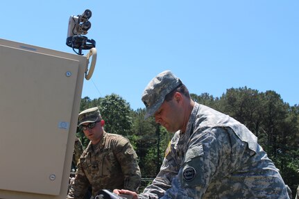 Spc. Ryan Mcelaney, left, and Sgt. 1st Class David Tate, both assigned to the 338th Transportation Detachment (Harbormaster) , work on the Harbormaster Command and Control Center at Joint Expeditionary Base Little Creek-Fort Story, Virginia Beach, Va. May 14, 2017. The Soldiers traveled to the area along with nearly 450 U.S. Army Reserve Soldiers for Big Logistics Over the Shore (Big LOTS) East 2017, a U.S. Army Reserve exercise that provides hands-on training for boat units, terminal battalions, and deployment support command units to sharpen critical tasks that support bare beach operations. (U.S. Army Reserve Photo by 1st Sgt. Angele Ringo)