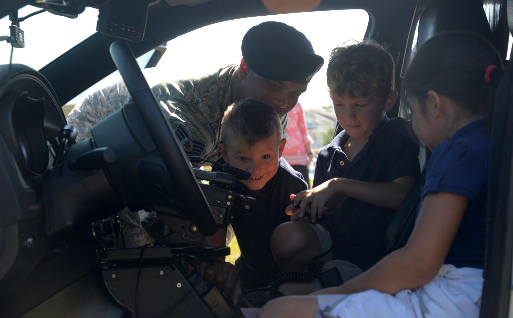 U.S. Air Force Tech. Sgt. Byron Taylor, NCO in charge of supply assigned to the 6th Security Forces Squadron (SFS), shows students from Tinker Elementary School how to turn on his police cars sirens at MacDill Air Force Base, Fla., May 16, 2017. The 6th SFS setup different displays and taught students weapon safety to celebrate National Police Week, May 15-21, 2017. (U.S. Air Force photo by Senior Airman Tori Long)