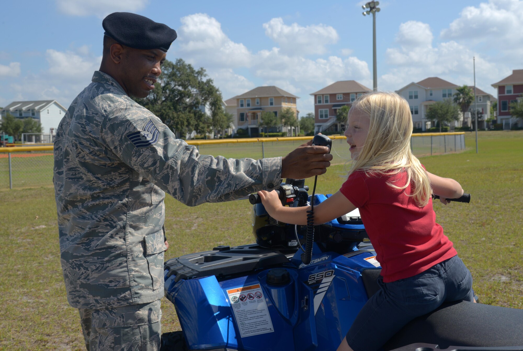 U.S. Air Force Tech. Sgt. Byron Taylor, NCO in charge of supply assigned to the 6th Security Forces Squadron (SFS), shows a student from Tinker Elementary School how to use the radio and lights of an all-terrain vehicle at MacDill Air Force Base, Fla., May 16, 2017. MacDill celebrated National Police Week with several events to commemorate the contributions and sacrifices of law enforcement officials around the world. (U.S. Air Force photo by Senior Airman Tori Long)