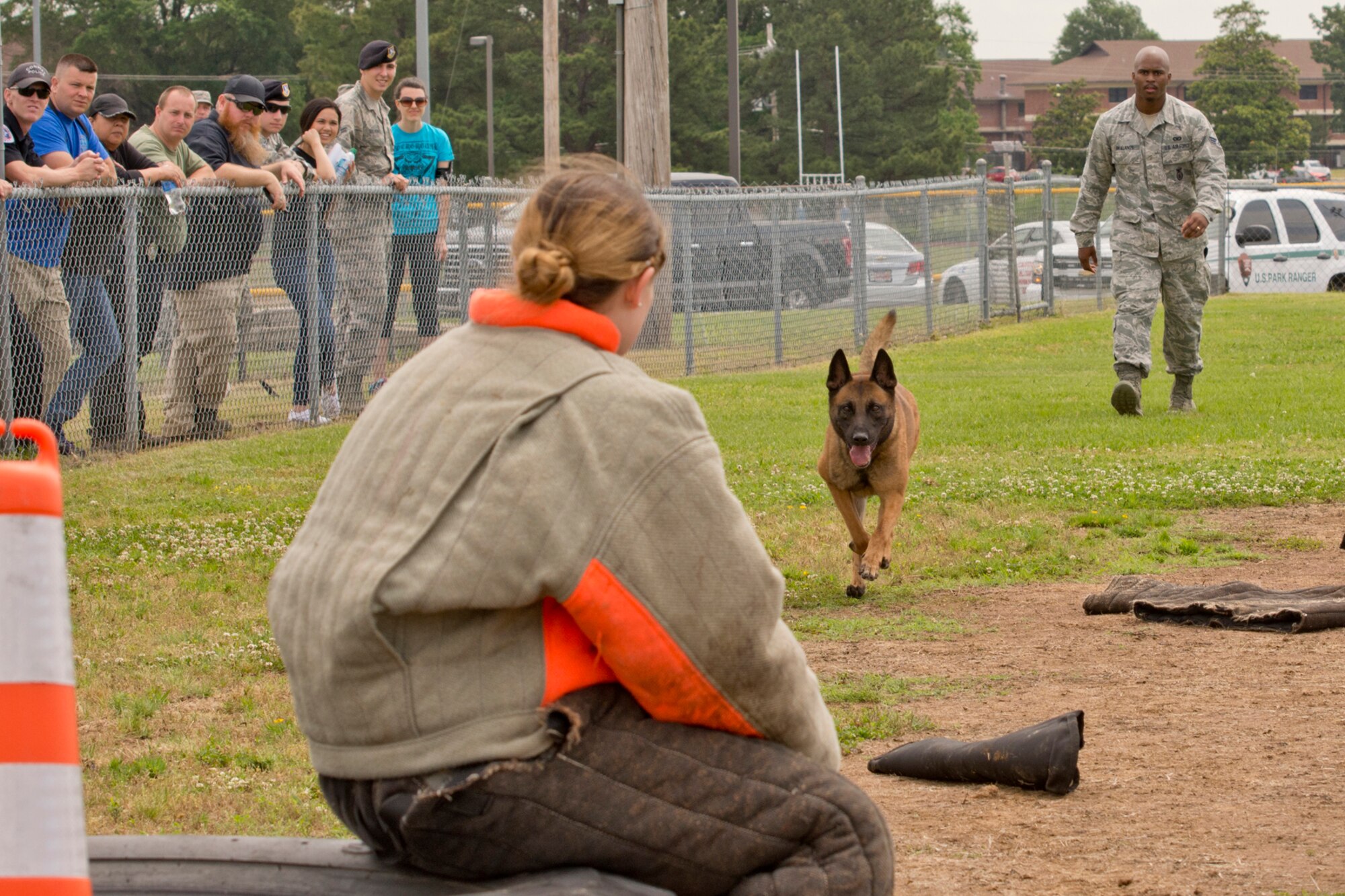 Freaki, a U.S. Air Force military working dog (MWD), maintains a lock on Senior Airman Ashley Evans, a 19th Security Forces Squadron patrolman, during the “Military Working Dog (MWD) Competition" at Little Rock Air Force Base, Ark., May 17, 2017. The competition, which included area law enforcement agencies, was held in honor of National Police Week, and was designed to conduct tactical obedience with multiple distractors to ensure the MWD would maintain keen focus on the decoy suspect sitting on the tire. The dogs had to bypass several bite sleeves and suits on the ground to reach the decoy. Freaki’s handler was Senior Airman Ndidi Akalanze, who is assigned to the 19th SFS. (U.S. Air Force photo by Master Sgt. Jeff Walston/Released)