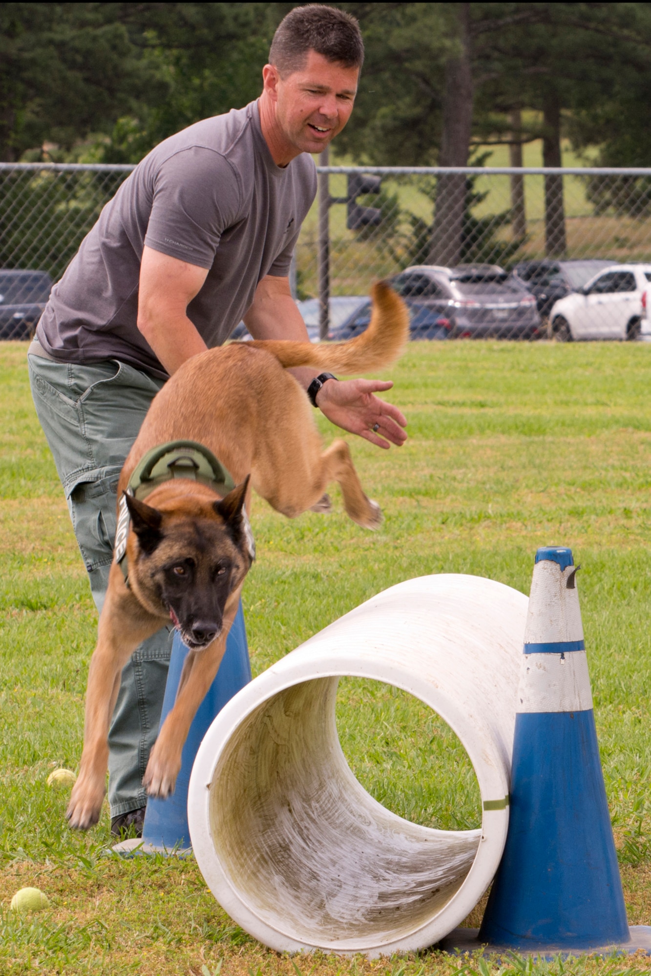 Police Officer Bruce Moyster, of the North Little Rock Police Department, tries to convince K9 Zeus, an 8-year-old Belgian Malinois, to go through a tube during the “Military Working Dog (MWD) Competition" at Little Rock Air Force Base, Ark., May 17, 2017. Zeus, a dual purpose K9, narcotics detector and patrol, has no experience going through culverts or tubes and found it easier just to go over it. (U.S. Air Force photo by Master Sgt. Jeff Walston/Released)