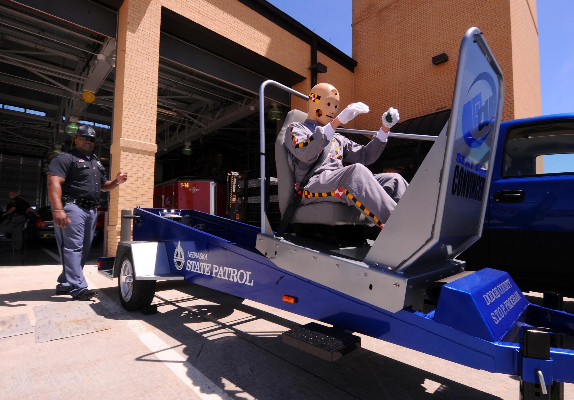 A Nebraska State Trooper uses a training aid to demonstrate the importance of seatbelts and child-restraints, even at relatively slow speeds, as part of a previous 55th Wing Safety Day. In addition to the typical booths manned by safety-conscious organizations like local energy providers, law enforcement agencies and non-profits, this event will include a motorcycle awareness demonstration, face-painting and balloons, military working dog demonstrations and an up-close look at the Omaha police department’s helicopter, ABLE 1. Food trucks will also be on-site to provide dining options for attendees.
