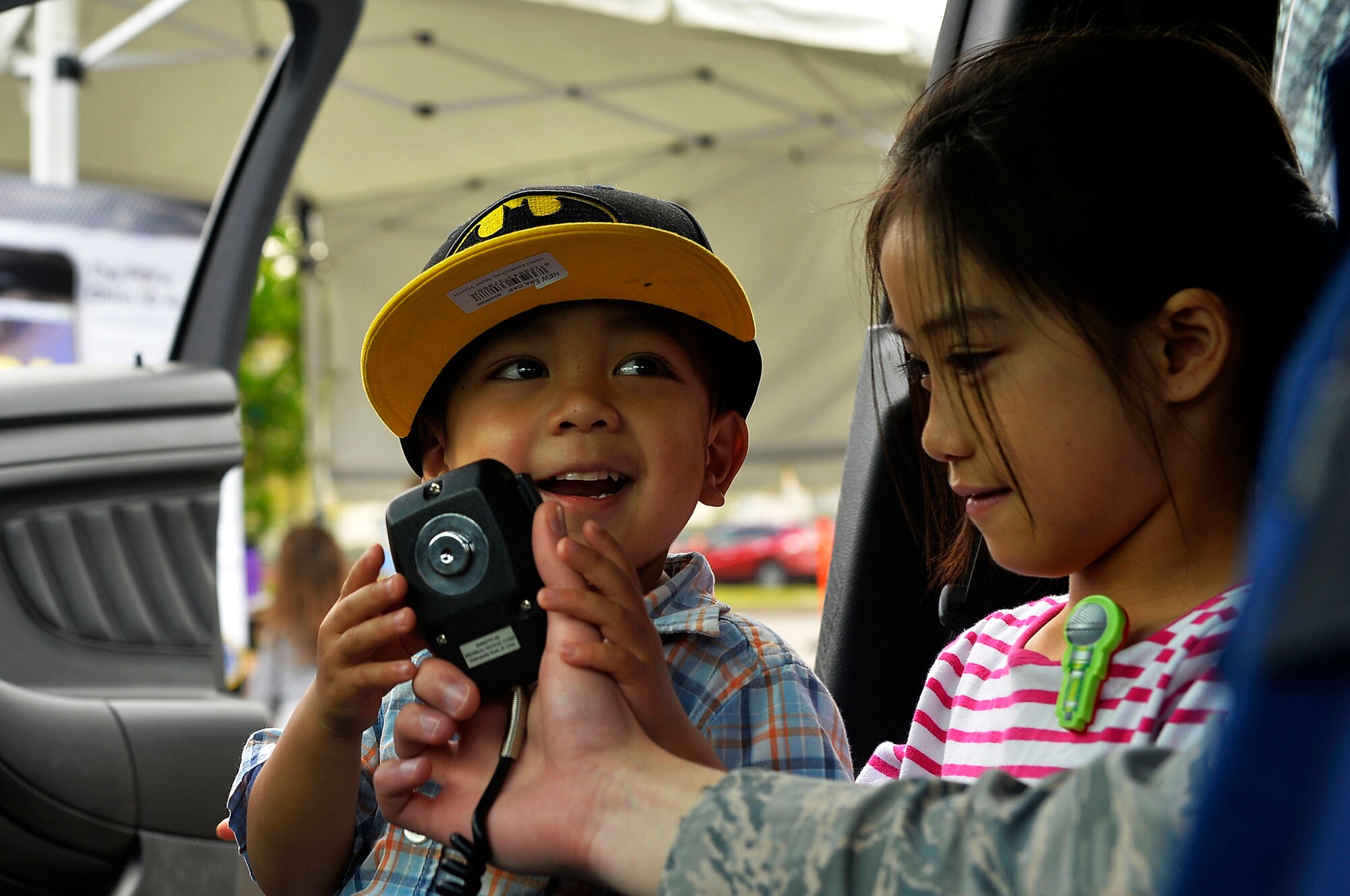 Children familiarize themselves with the public announcement system of a police vehicle on Ramstein Air Base, Germany, May 13, 2017. Ramstein hosted a family-friendly police display which included a variety of exhibits and static displays in support of Police Week. (U.S. Air Force photo by Airman 1st Class Joshua Magbanua) 