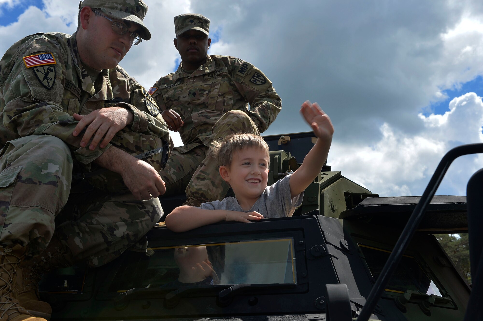 A child waves to his parents from the top of an Army armored security vehicle during a Police Week event on Ramstein Air Base, Germany, May 13, 2017. Ramstein hosted the family-friendly police exhibition in order to build relations with the community. (U.S. Air Force photo by Airman 1st Class Joshua Magbanua) 