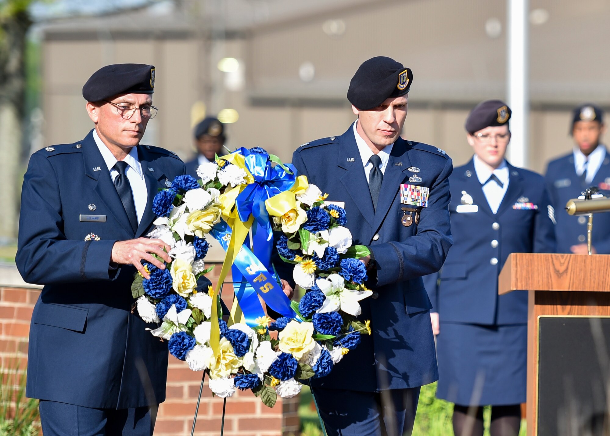 Lt. Col. Scott Stewart, 910th Security Forces Squadron commander, and Capt. Nicholas Megyesi, SFS operations officer, lay a commemorative wreath at the base of the flag pole during a Police Week ceremony here, May 17, 2017.  SFS held the ceremony with representatives from local law enforcement agencies. The ceremony honored the selfless service of U.S. police officers who have fallen in the line of duty. (U.S. Air Force photo/Eric White)