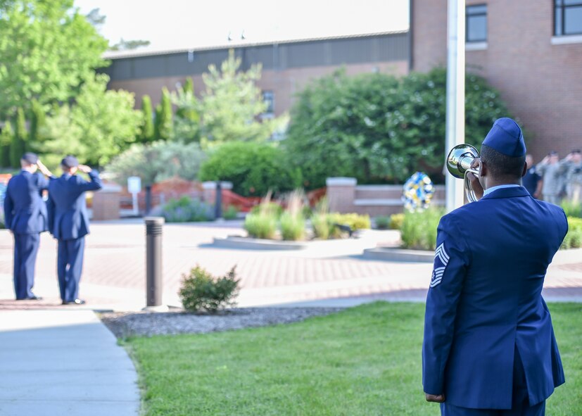 Chief Master Sgt. Shawn White, representing the 910th Airlift Wing Color Guard and Honor Guard, signals taps during a Police Week ceremony here, May 17, 2017, while 910th Security Forces Squadron members and local law enforcement agency officers salute. SFS held the ceremony in recognition of Police Week to honor police officers who have given their lives in the line of duty. (U.S. Air Force photo/Eric White)