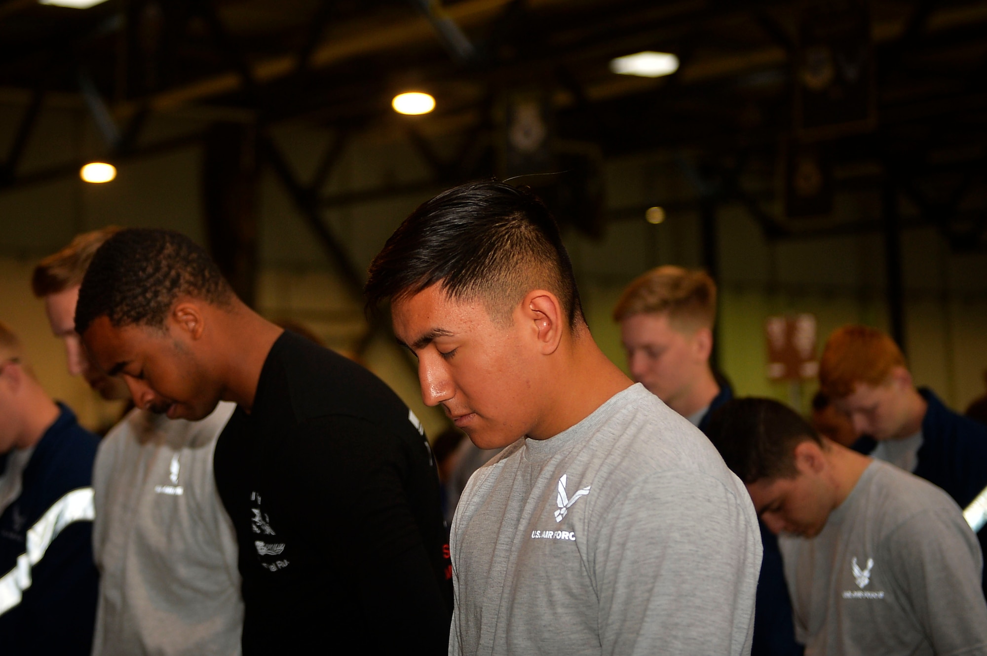 721st Aerial Port Squadron Airmen bow their heads in prayer during as they prepare for a memorial run on Ramstein Air Base, Germany, May 19, 2017. The Airmen honored four of their colleagues from different bases who lost their lives over the past year. (U.S. Air Force photo by Airman 1st Class Joshua Magbanua)