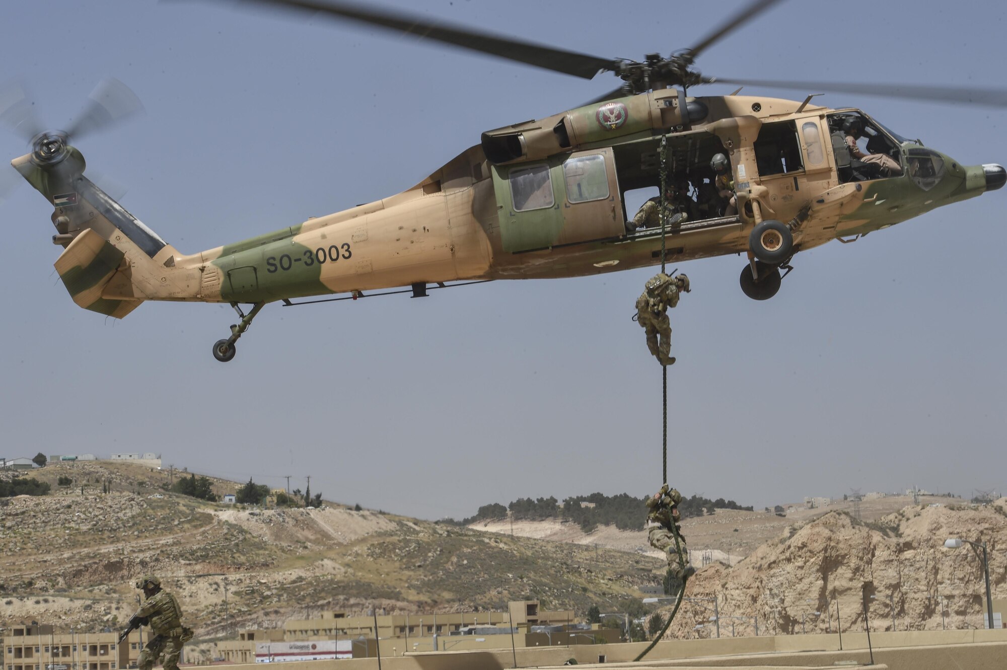 Italian special operations forces, U.S. Air Force Special Tactics and members of the Jordanian Armed Forces Special Task Force fast rope from a Royal Jordanian Air Force UH-60L Blackhawk helicopter onto a three-story building during Exercise Eager Lion May 11, 2017, at King Abdullah II Special Operations Training Center. (U.S. Air Force photo by SrA Ryan Conroy)