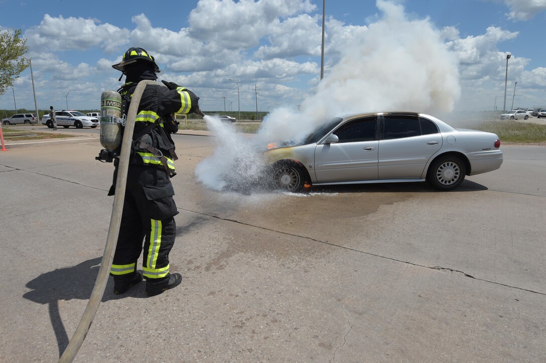 William Green, a Tinker Fire and Emergency Services firefighter, sprays water on a vehicle which caught fire May 4, 2017, at Tinker Air Force Base, Okla. The privately owned vehicle developed mechanical trouble and caught fire near the Oklahoma City Air Logistics Complexs' building 9001. The fire was quickly and safely extinguished using water and powder while traffic was diverted to an alternate route as workers completed their shifts. Tinker Fire and Emergency Services is a division of the 72nd Civil Engineer Squadron. (U.S. Air Force photo/Greg L. Davis)