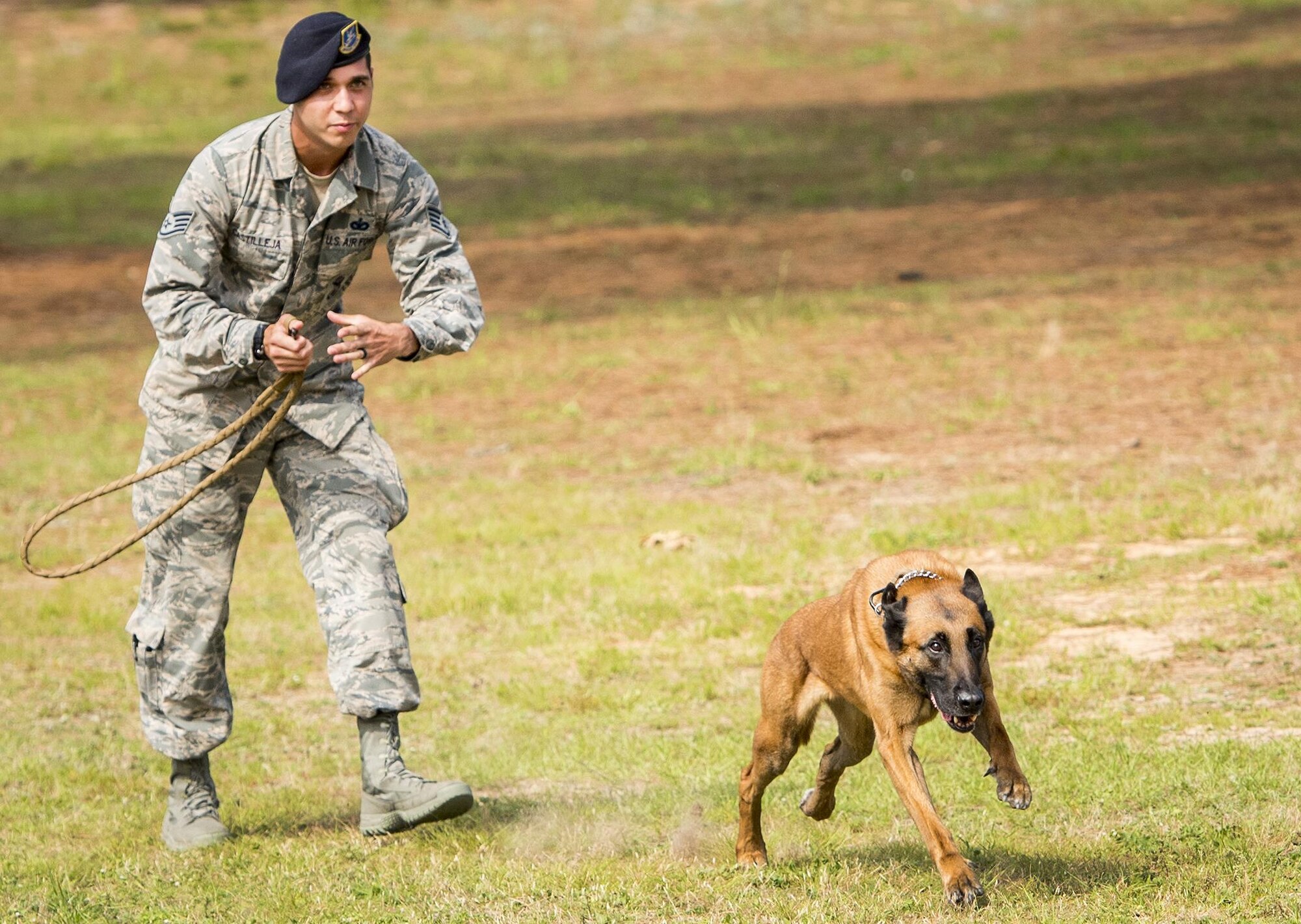 Staff Sgt. Michael Castilleja, 96th Security Forces Squadron, releases Military Working Dog Arko to take down a simulated assailant during a demonstration for Eglin Elementary School kids May 18 at Eglin Air Force Base, Fla. The event was in celebration of National Police Week. More than 100 children watched the demonstration. (U.S. Air Force photo/Samuel King Jr.)