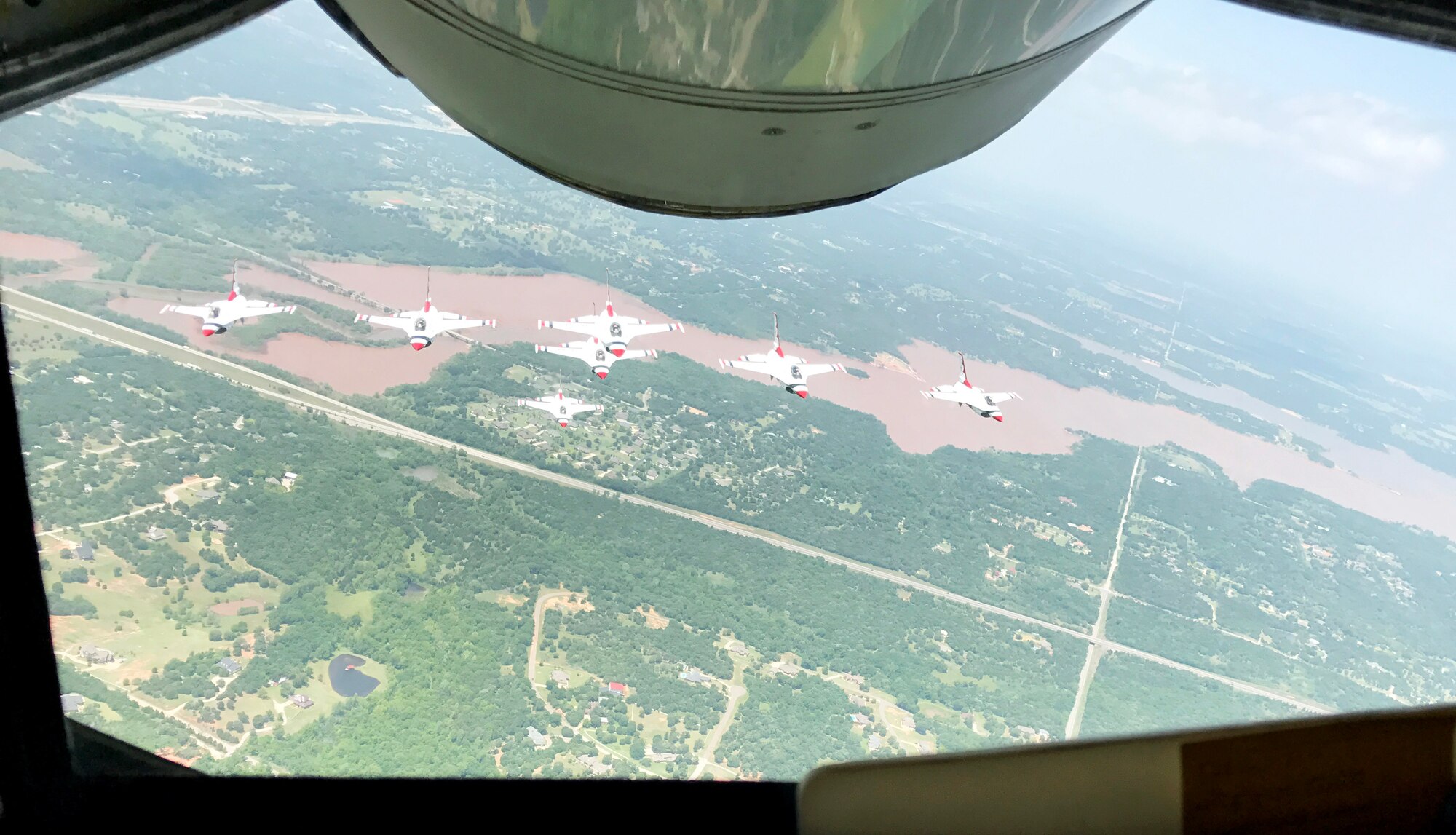 Seven U.S. Air Force Thunderbirds fly in formation over Lake Arcadia behind a Reserve KC-135 Stratotanker assigned to the 465th Air Refueling Squadron, 507th Air Refueling Wing, May 18, 2017, prior to landing at Tinker Air Force Base for the 2017 Star Spangled Salute Air Show. (U.S. Air Force photo/Tech. Sgt. Lauren Gleason/Released) 
