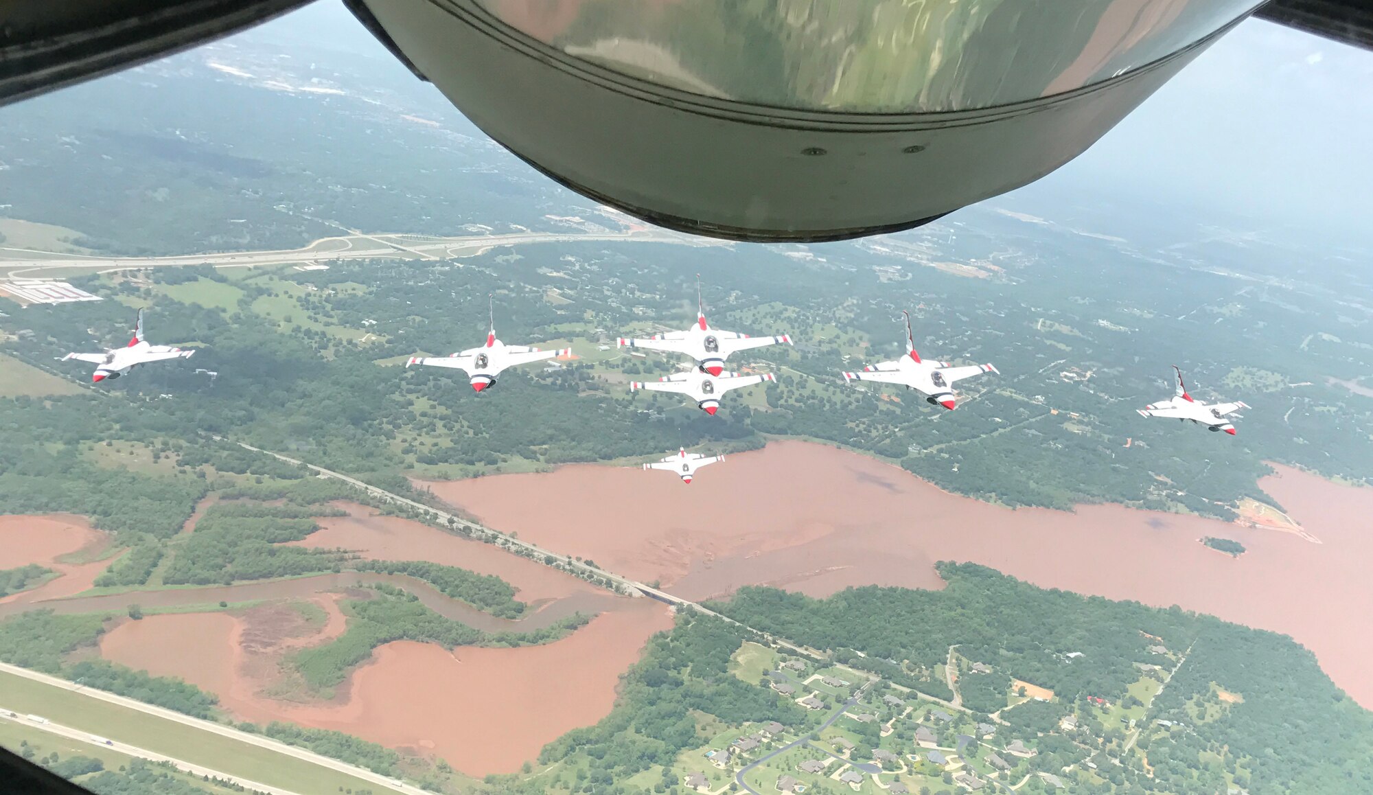 Seven U.S. Air Force Thunderbirds fly in formation over Lake Arcadia behind a Reserve KC-135 Stratotanker assigned to the 465th Air Refueling Squadron, 507th Air Refueling Wing, May 18, 2017, prior to landing at Tinker Air Force Base for the 2017 Star Spangled Salute Air Show. (U.S. Air Force photo/Tech. Sgt. Lauren Gleason/Released) 