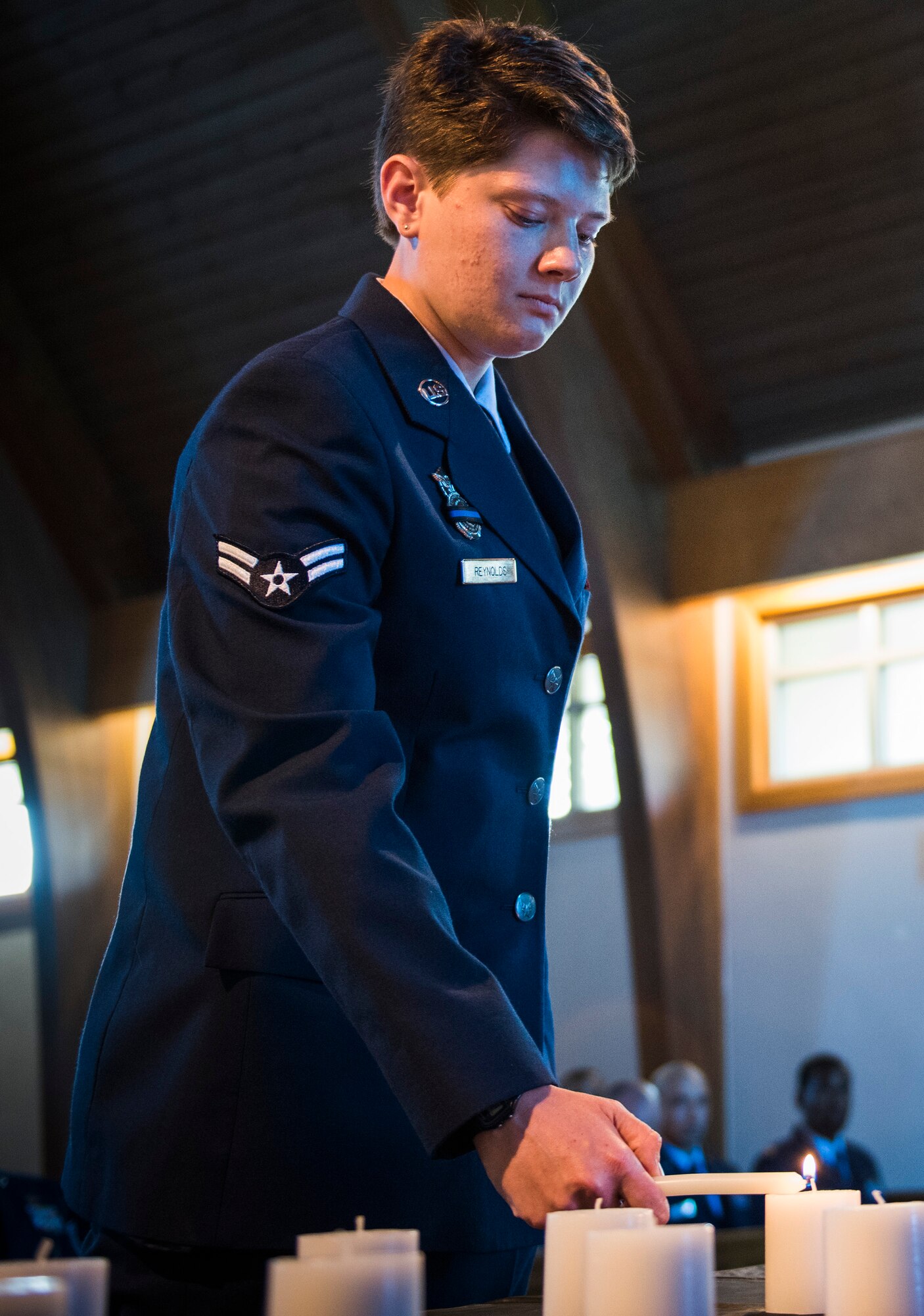 Airman 1st Class Marissa Reynolds, 96th Security Forces Squadron, lights a candle during the National Police Week candlelight vigil May 18 at Eglin Air Force Base, Fla. The ceremony was held to honor the police, defenders and the agents who paid the ultimate sacrifice in the line of duty. To remember them, 14 candles were lit. (U.S. Air Force photo/Ilka Cole)