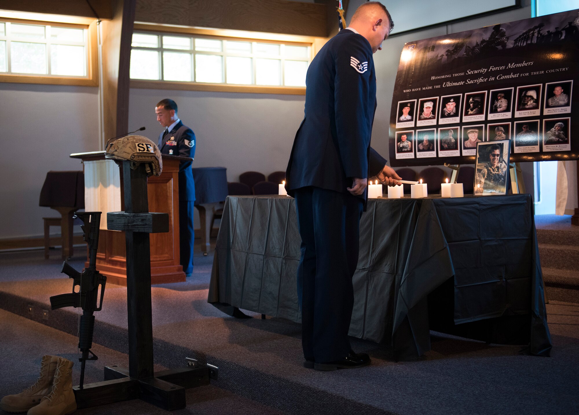 A 96th Security Forces Squadron Airman lights a candle during the National Police Week candlelight vigil May 18 at Eglin Air Force Base, Fla. The ceremony was held to honor the police, defenders and the agents who paid the ultimate sacrifice in the line of duty. To remember them 14 candles were lit. (U.S. Air Force photo/Ilka Cole)