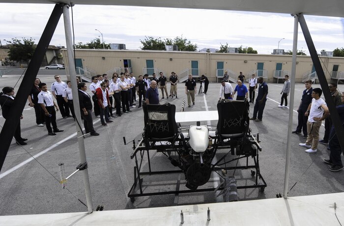 Faculty and students examine the engine of the USU Wright Flyer at Rancho High School, May 15, 2017. The flyer arrived in pieces from Ohio so the aviation students can learn from the process of piecing the aircraft back together. (U.S. Air Force photo by Senior Airman Kevin Tanenbaum)