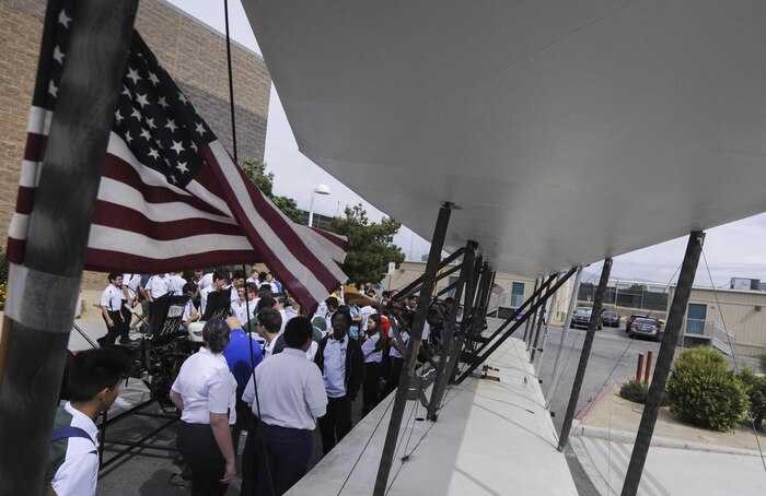 Aviation students from Rancho High School gather around the USU Wright Flyer after it was unloaded at Rancho High School, North Las Vegas, May 15, 2017. The flyer is one of six existing scale models of the Wright Brothers’ original aircraft. (U.S. Air Force photo by Senior Airman Kevin Tanenbaum/Released)