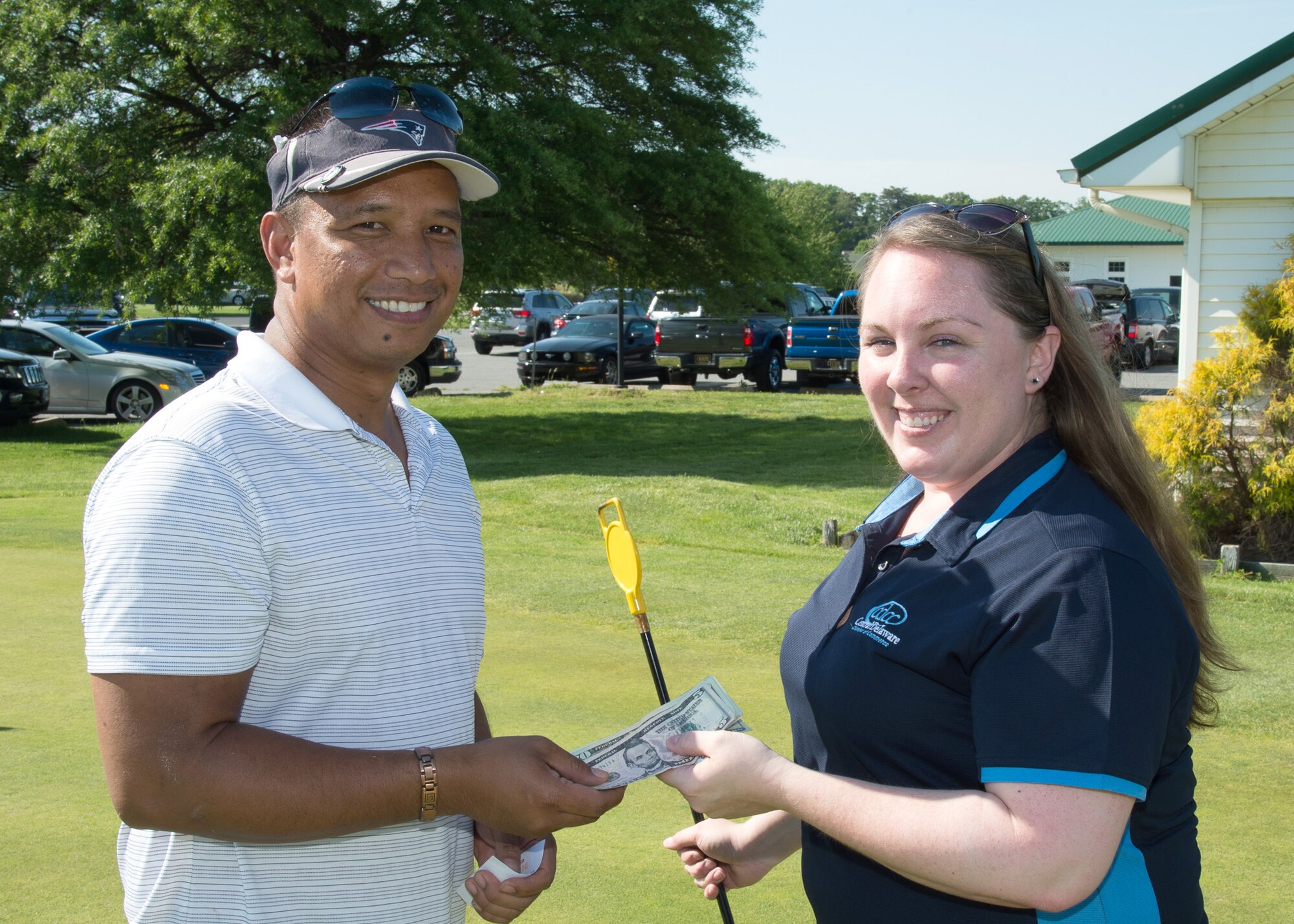 Cristal Brenneman, Central Delaware Chamber of Commerce Director of Special Events, awards Erol Gutierrez, shift manager at the Harrington Casino, prize money at the 2017 spring Bluesuiters Golf Tournament May 17, 2017, 2016, at the Jonathan’s Landing Golf Course in Magnolia, Delaware. Gutierrez won the prize money when his golf ball landed closest to the putting hole. (U.S. Air Force photo by Mauricio Campino)