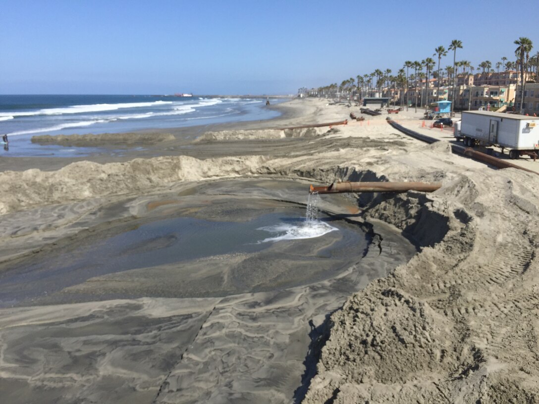 Manson Construction Company places material from the Oceanside Harbor channel dredging project immediately north of the Oceanside Pier. The project is an annual effort to maintain safe navigation for vessels that use the harbor.