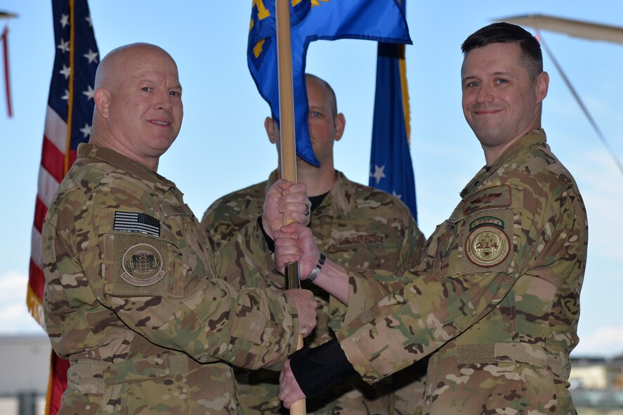 Maj. Jeremy McPherson, right, accepts command of the 582nd Operations Support Squadron Detachment 4 from Lt. Col. Christopher Roness, 582nd OSS commander, May 19, 2017, at Malmstrom Air Force Base, Mont. Master Sgt. Daniel Hockenberry, 582nd OSS Detachment 4 superintendent, looks on. (U.S. Air Force photo/Airman 1st Class Daniel Brosam)