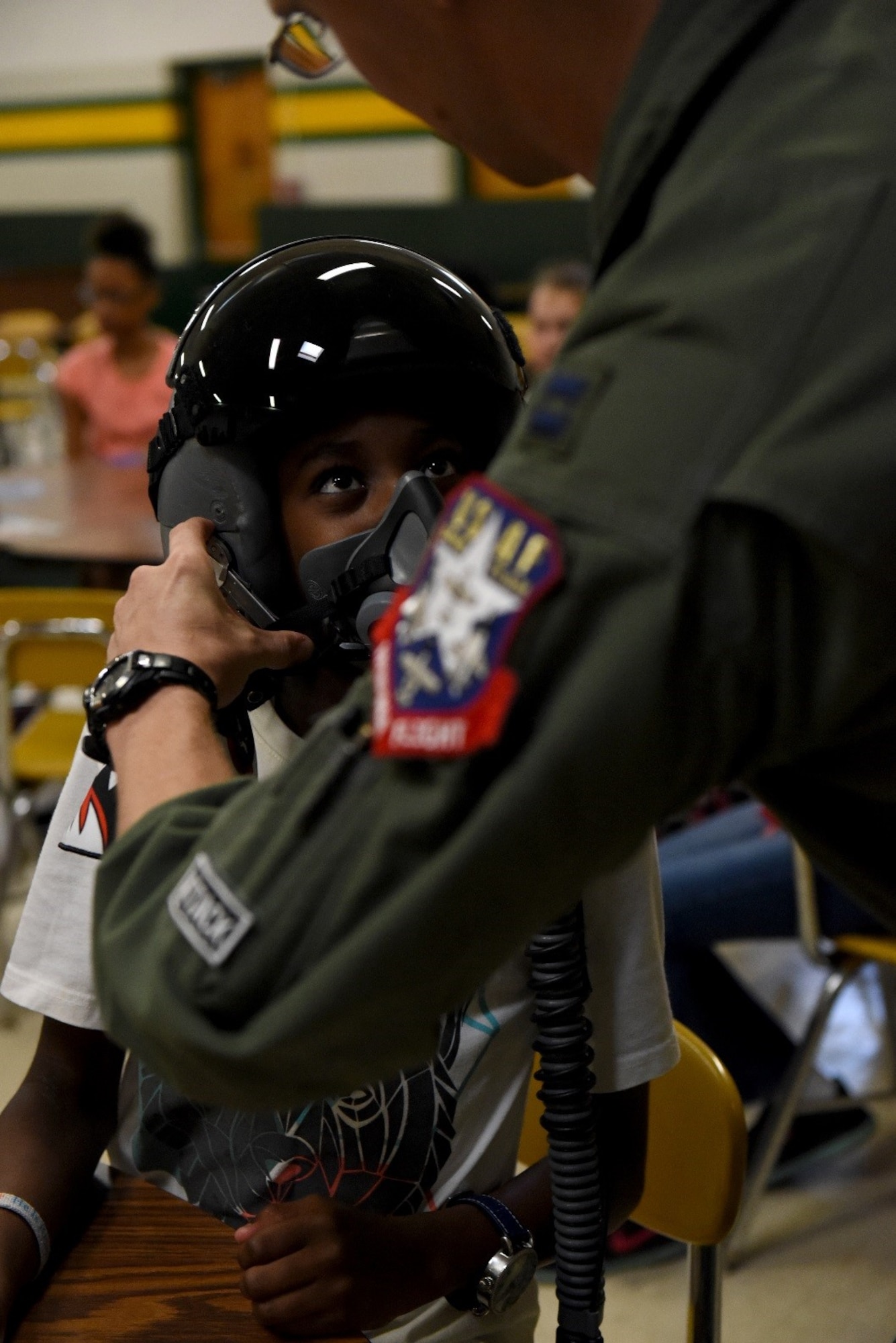 A student from Greenwood Middle School tries on a U.S. Air Force pilot’s helmet, May 19, 2017, in Goldsboro, North Carolina. Students had the opportunity to speak with both aircrew and maintainers prior to the Wings Over Wayne Air Show at Seymour Johnson Air Force Base, May 20-21, 2017.  (U.S. Air Force photo by Airman 1st Class Victoria Boyton)