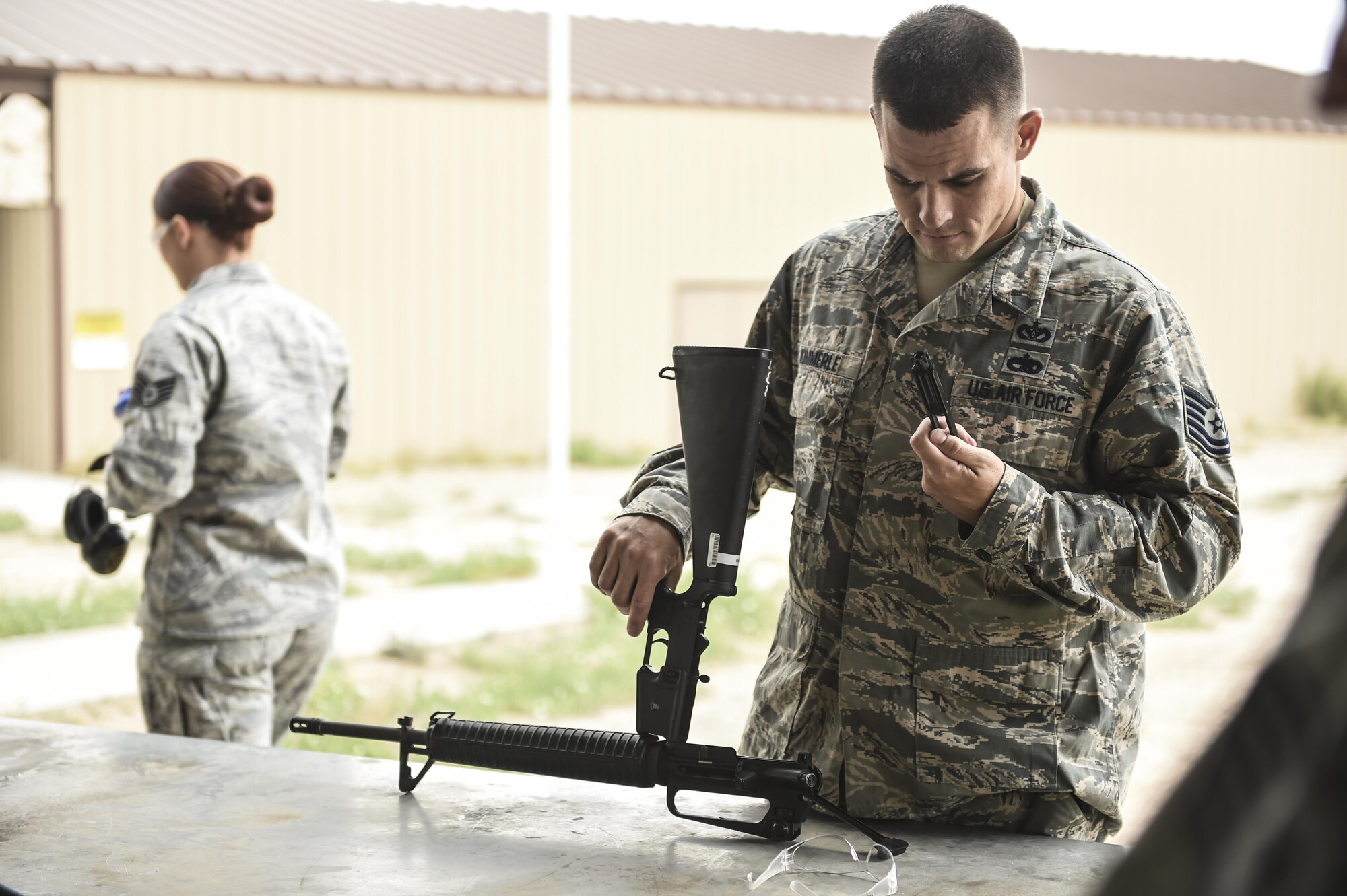 Tech. Sgt. Benjamin Kimmerle, 49th Civil Engineer Squadron checks and assembles his weapon prior to the shooting competition held during National Police Week at Holloman Air Force Base, N.M. on May 15, 2017. National Police Week was established in 1962 by President John F. Kennedy to pay tribute to law enforcement officers who lost their lives in the line of duty for the safety and protection of others, according to the National Peace Officer's Memorial Fund website. Ceremonies are held annually in Washington D.C., as well as in communities across the nation. (U.S. Air Force photo by Staff Sgt. Stacy Jonsgaard)    