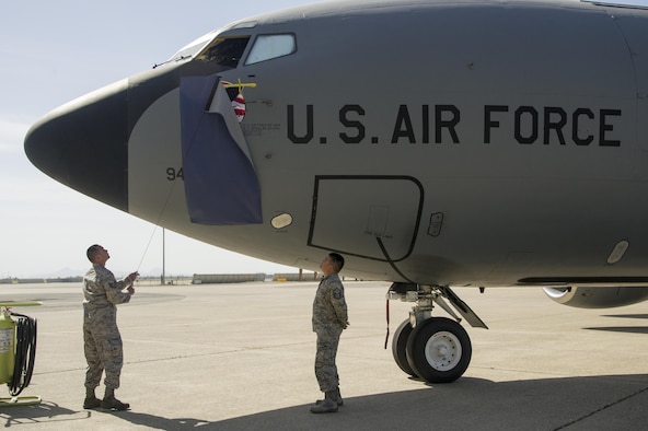 Two members of the 940th Air Refueling Wing unveil the “Let’s Roll!” nose art May 7, 2017, at Beale Air Force Base, California. “Let’s Roll!” was the wing’s second nose art to be placed on one of their KC-13 Statotankers since being re-designated as an air refueling wing last year. (U.S. Air Force photo by Senior Airman Tara R. Abrahams)