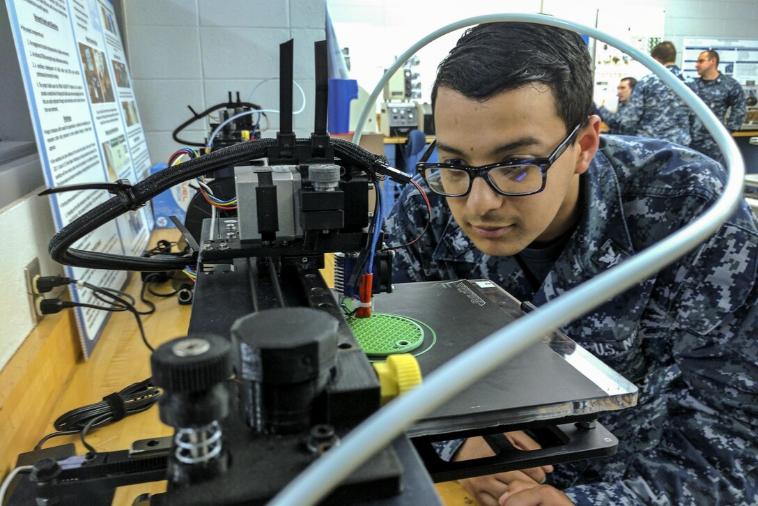 Navy Petty Officer 3rd Class Daniel Pastor examines a 3-D printer during a 3-D design and production course at Old Dominion University in Norfolk, Va., May 13, 2017, as part of the university’s FleetMaker program. The program teaches service members how to design and print objects and parts that can help the fleet. Pastor is an information systems technician. Navy photo by Petty Officer 2nd Class Rawad Madanat