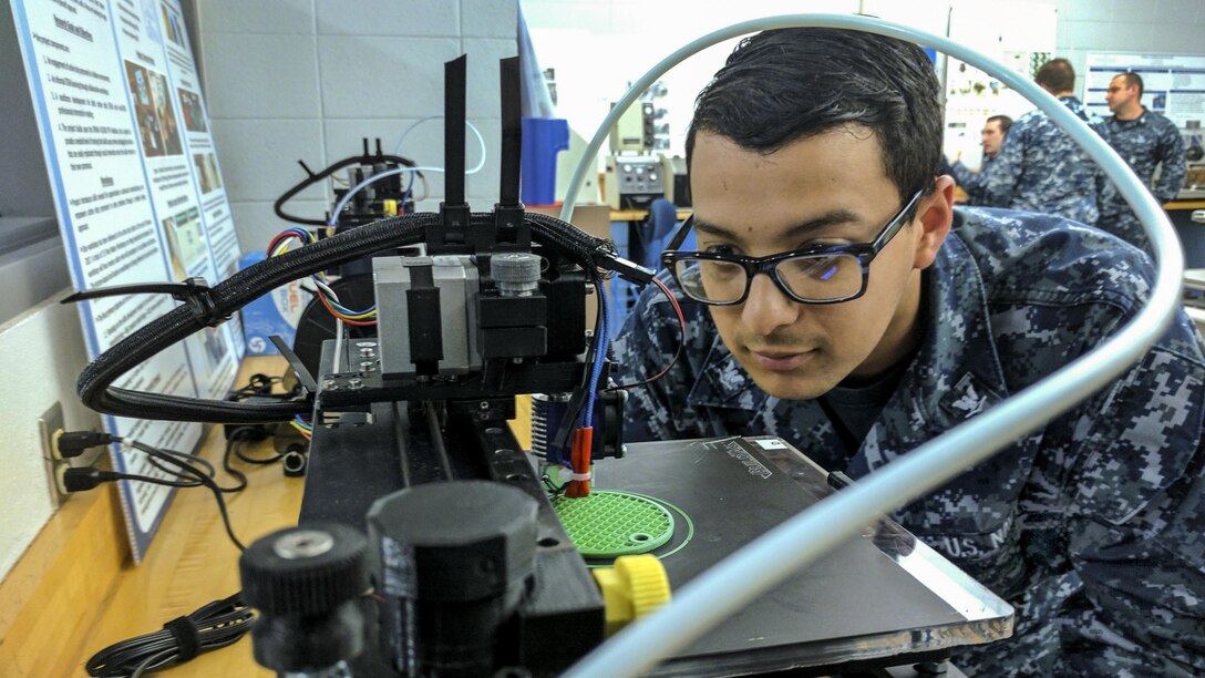 Navy Petty Officer 3rd Class Daniel Pastor examines a 3-D printer during a 3-D design and production course at Old Dominion University in Norfolk, Va., May 13, 2017, as part of the university’s FleetMaker program. The program teaches service members how to design and print objects and parts that can help the fleet. Pastor is an information systems technician. Navy photo by Petty Officer 2nd Class Rawad Madanat