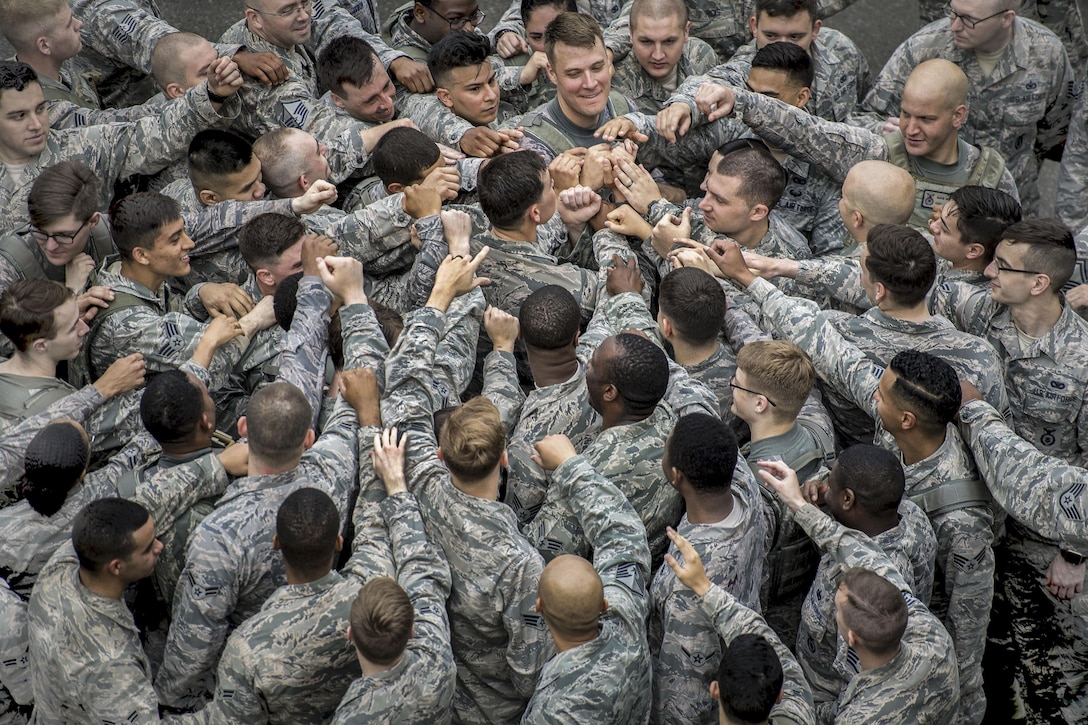 Airmen join in a group huddle at the conclusion of the Police Week Memorial 5K Ruck March at Yokota Air Base, Japan, May 15, 2017. The airmen are assigned to the 374th Security Forces Squadron. Air Force photo by Airman 1st Class Donald Hudson