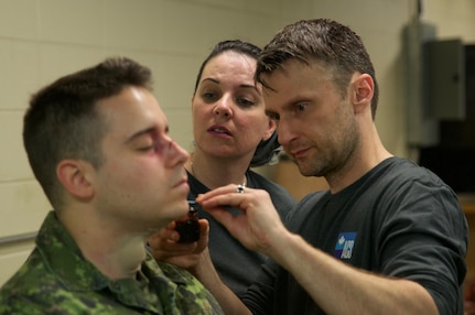 Special effects team members Jenni MacDonald and Stacy Wegner apply prosthetic wounds to a role player who will act as a simulated casualty on a training mission as part of Maple Resolve 17, the Canadian Army's premiere brigade-level validation exercise running May 14-29 at Camp Wainwright, Alberta, Canada. The role players fulfill an integral part for the training, allowing the Soldiers to react to life-like, real-time situations ranging from medevac, hostile enemies and media engagements.

As a part of the exercise, the U.S. Army is providing a wide array of combat and support elements. These elements include sustainment, psychological operations, public affairs, aviation and medical units. Readiness is the U.S. Army Reserve's number one priority. Reserve units participating in Maple Resolve 17 will sharpen individual skill sets while enhancing overall unit readiness.