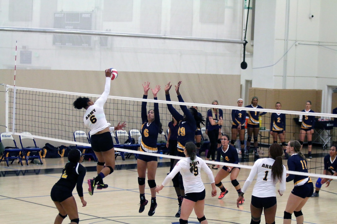 Army Sgt. Latoya Marshall of Wilminton, N.C. drives through Navy blockers in match 5 of the 2017 Armed Forces Women's Volleyball Championship at Naval Station Mayport, Florida on 18 May.