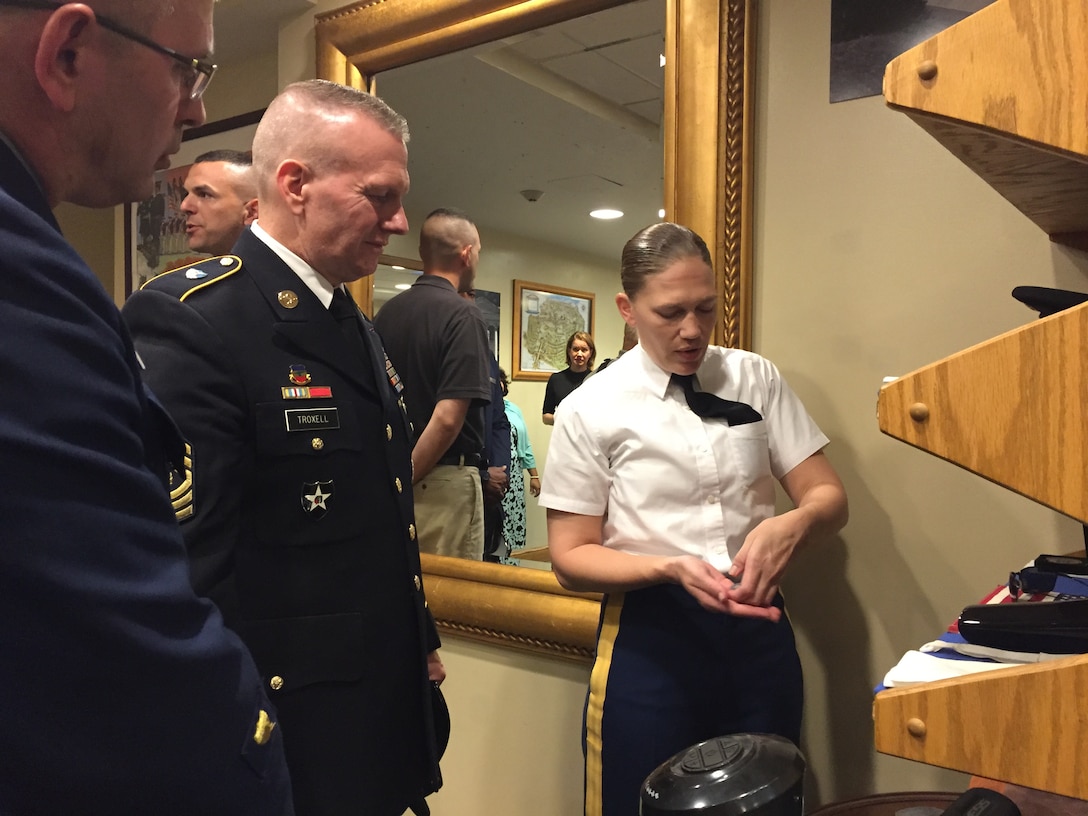 Army Staff Sgt. Ruth Hanks, the Tomb of the Unknowns sergeant of the guard, explains what the accouterments on her uniform mean to Army Command Sgt. Maj. John W. Troxell, the senior enlisted advisor to the chairman of the Joint Chiefs of Staff, and Master Chief Petty Officer of the Coast Guard Steven W. Cantrell at Arlington National Cemetery, Va., May 20, 2017. DoD photo by Jim Garamone