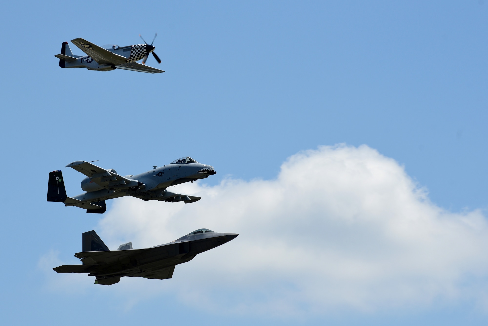 A P-51D Mustang, F-22 Raptor and A-10 Thunderbolt perform a tribute flight during the Wings Over Wayne Air Show, May 20, 2017, at Seymour Johnson Air Force Base, North Carolina. The formation consisted of aircraft dating back to World War II to current 5th-generation aircraft. (U.S. Air Force photo by Airman 1st Class Kenneth Boyton)