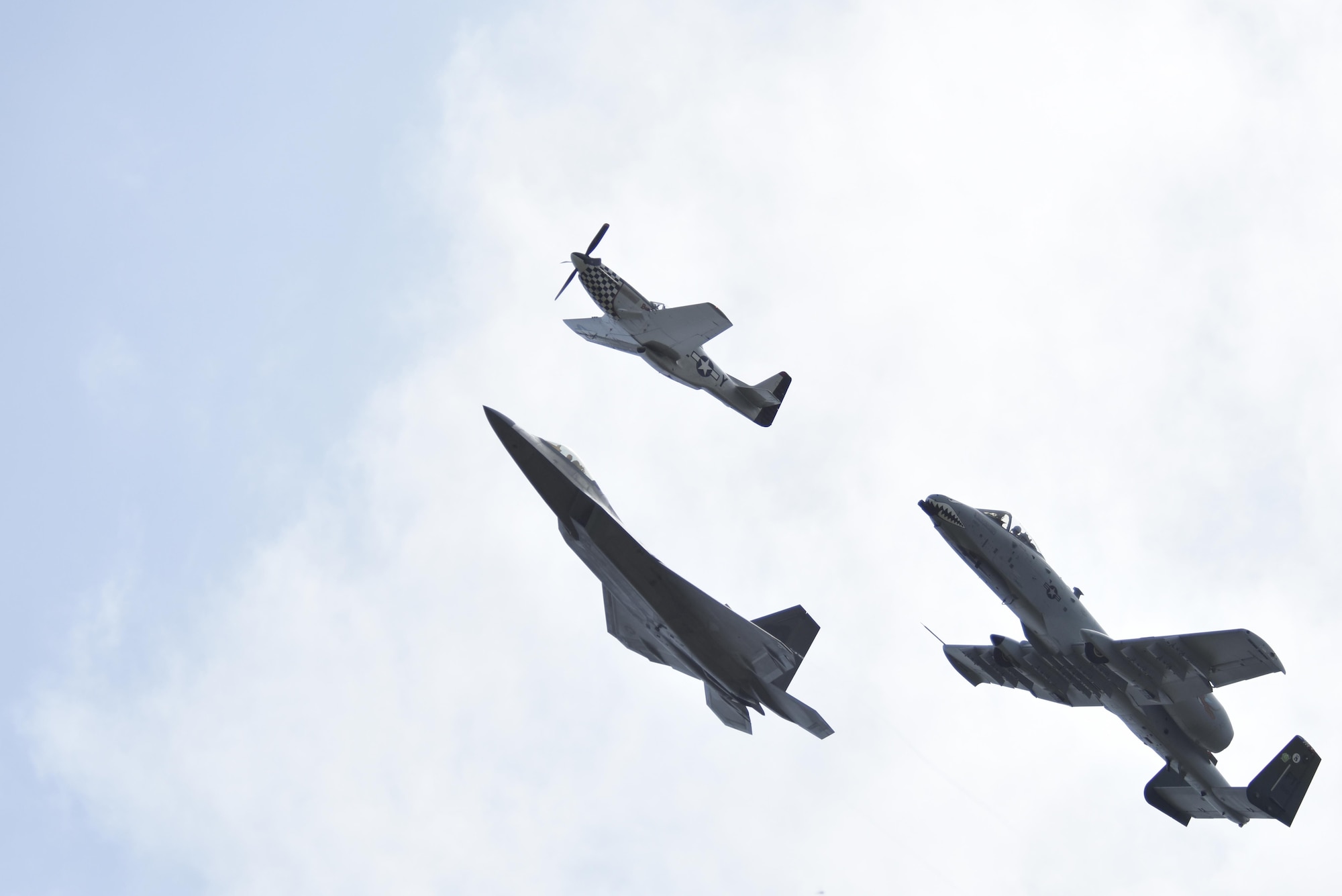 A P-51D Mustang, F-22 Raptor and A-10 Thunderbolt perform a tribute flight during the Wings Over Wayne Air Show, May 21, 2017, at Seymour Johnson Air Force Base, North Carolina. The formation consisted of aircraft dating back to World War II to current 5th generation aircraft. (U.S. Air Force photo by Airman 1st Class Christopher Maldonado)