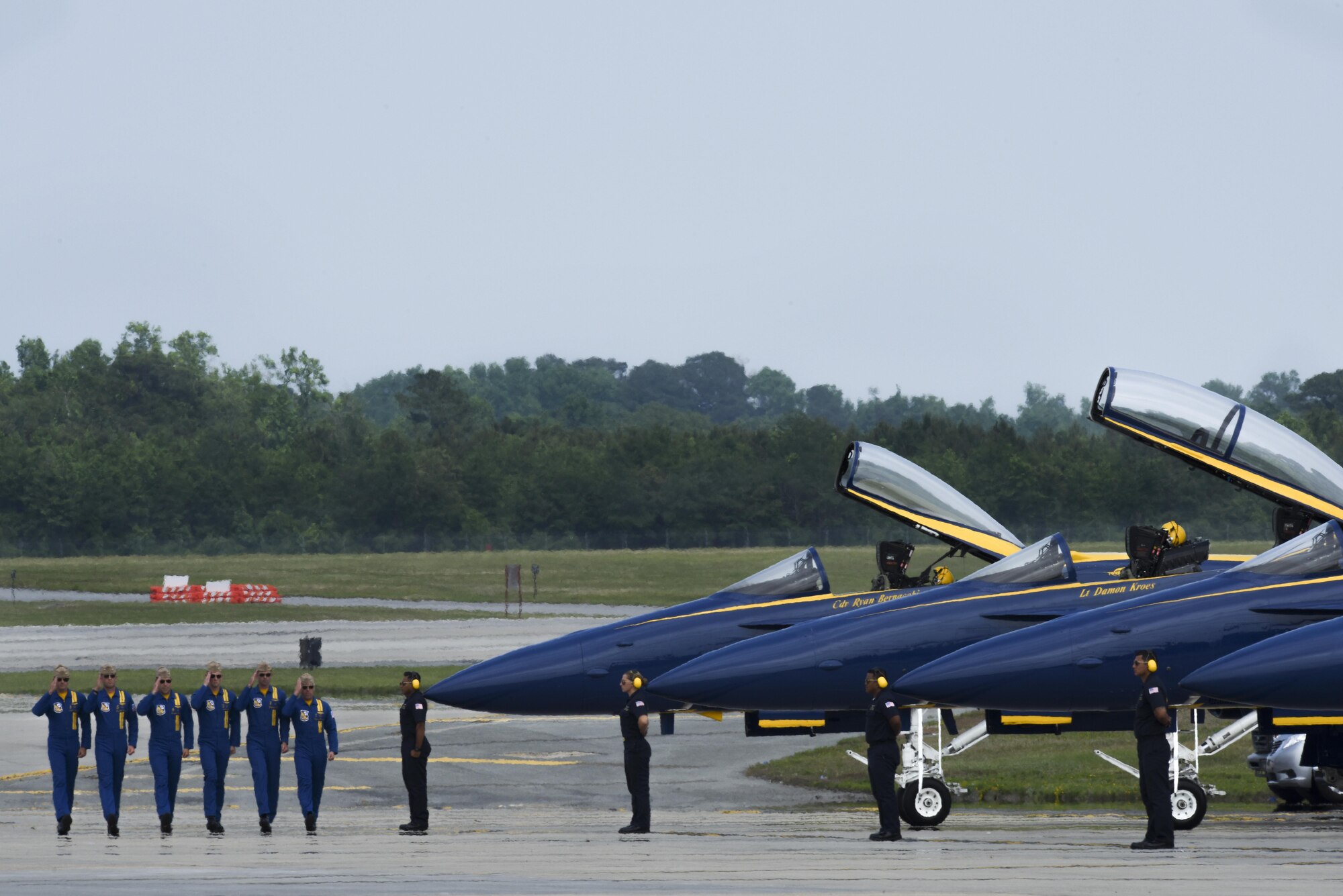 The U.S. Navy Blue Angels salute as they approach their aircraft during the Wings Over Wayne Air Show, May 21, 2017, at Seymour Johnson Air Force Base, North Carolina. The Blue Angels team consists of 17 officers and more than 100 enlisted Sailors and Marines who serve support and maintenance roles. (U.S. Air Force photo by Staff Sgt. Brittain Crolley)