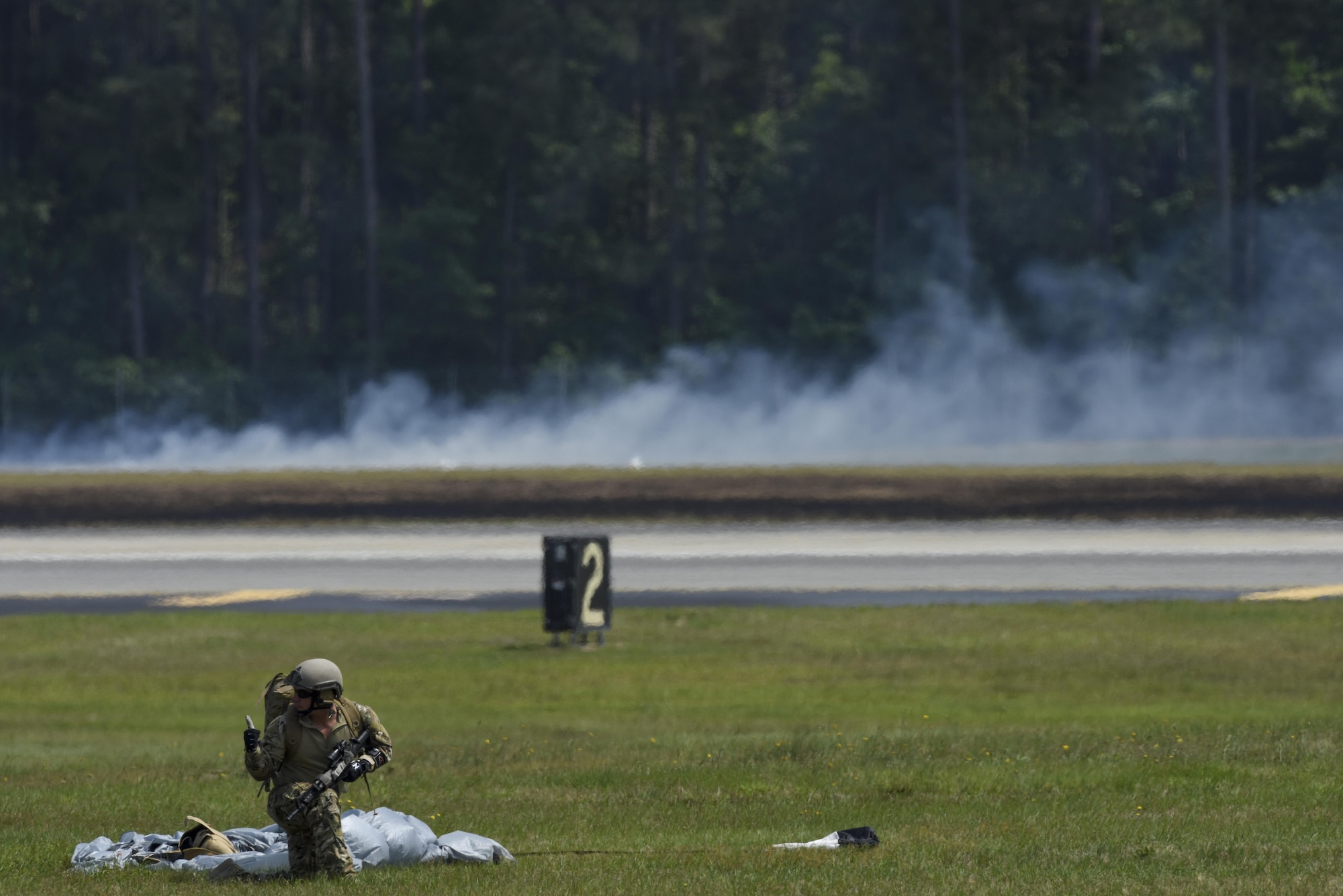 A joint terminal attack controller signals a teammate as part of a combined arms demonstration during the Wings Over Wayne Air Show, May 21, 2017, at Seymour Johnson Air Force Base, North Carolina. During the demonstration, the JTACs called in air support to alleviate a troops-in-contact situation. (U.S. Air Force photo by Staff Sgt. Brittain Crolley)