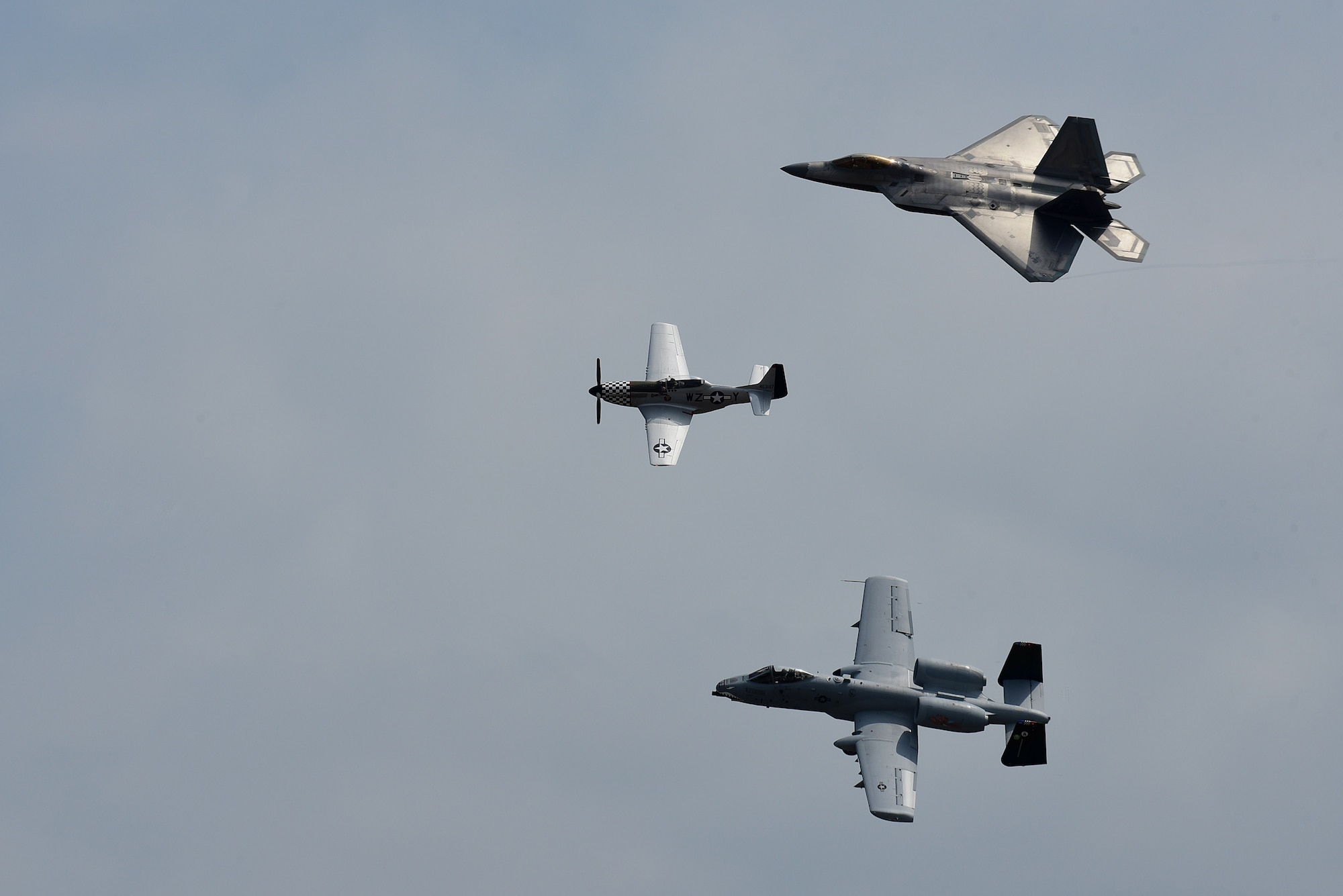 A P-51D Mustang, F-22 Raptor and A-10 Thunderbolt perform a tribute flight during the Wings Over Wayne Air Show, May 21, 2017, at Seymour Johnson Air Force Base, North Carolina. The formation consisted of aircraft dating back to World War II to current 5th-generation aircraft. (U.S. Air Force photo b Airman 1st Class Kenneth Boyton)