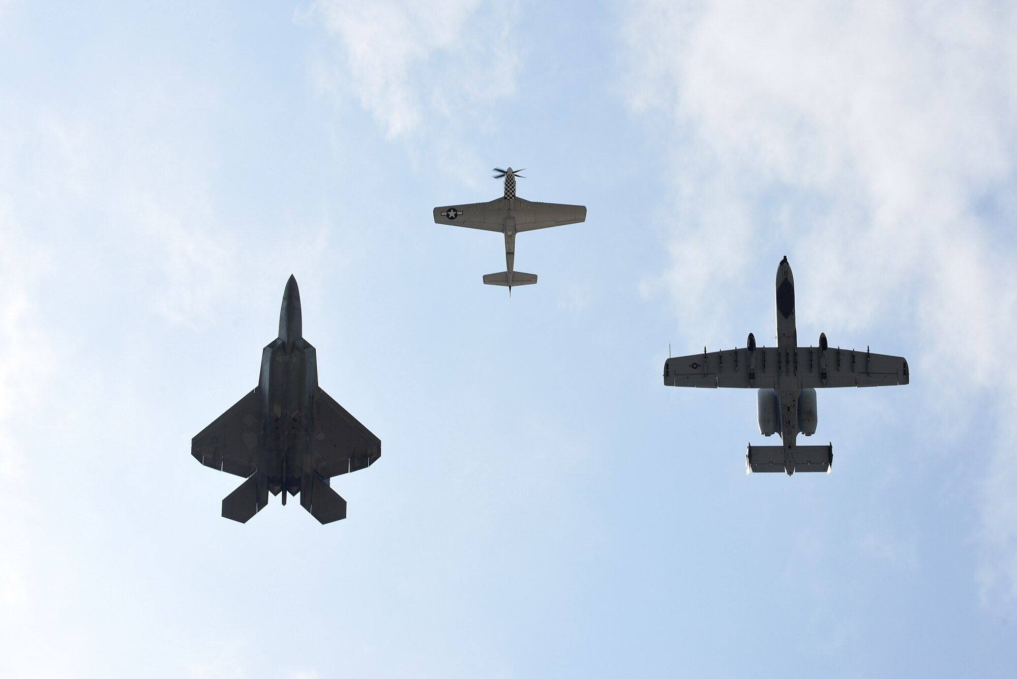 A P-51D Mustang, F-22 Raptor and A-10 Thunderbolt perform a tribute flight during the Wings Over Wayne Air Show, May 21, 2017, at Seymour Johnson Air Force Base, North Carolina. The formation consisted of aircraft dating back to World War II to current 5th-generation aircraft. (U.S. Air Force photo b Airman 1st Class Kenneth Boyton)