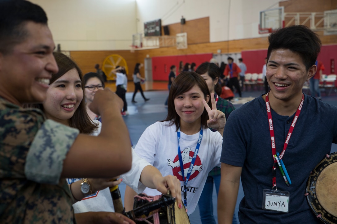 Japanese students from Nikkei Business School in Okinawa City, Okinawa, Japan teach Marines with III Marine Expeditionary Force how to play traditional Okinawan music, at the House of Pain Fitness Center, on Camp Hansen, Okinawa, during the Okinawan-American Cultural Exchange Day, May 19, 2017. The Marines with III MEF Headquarters Group hosted the cultural exchange day to strengthen bonds between local nationals and service members, providing the two communities with the opportunity to converse and learn about each other’s culture. (U.S. Marine Corp photo by Lance Cpl. Charles Plouffe)