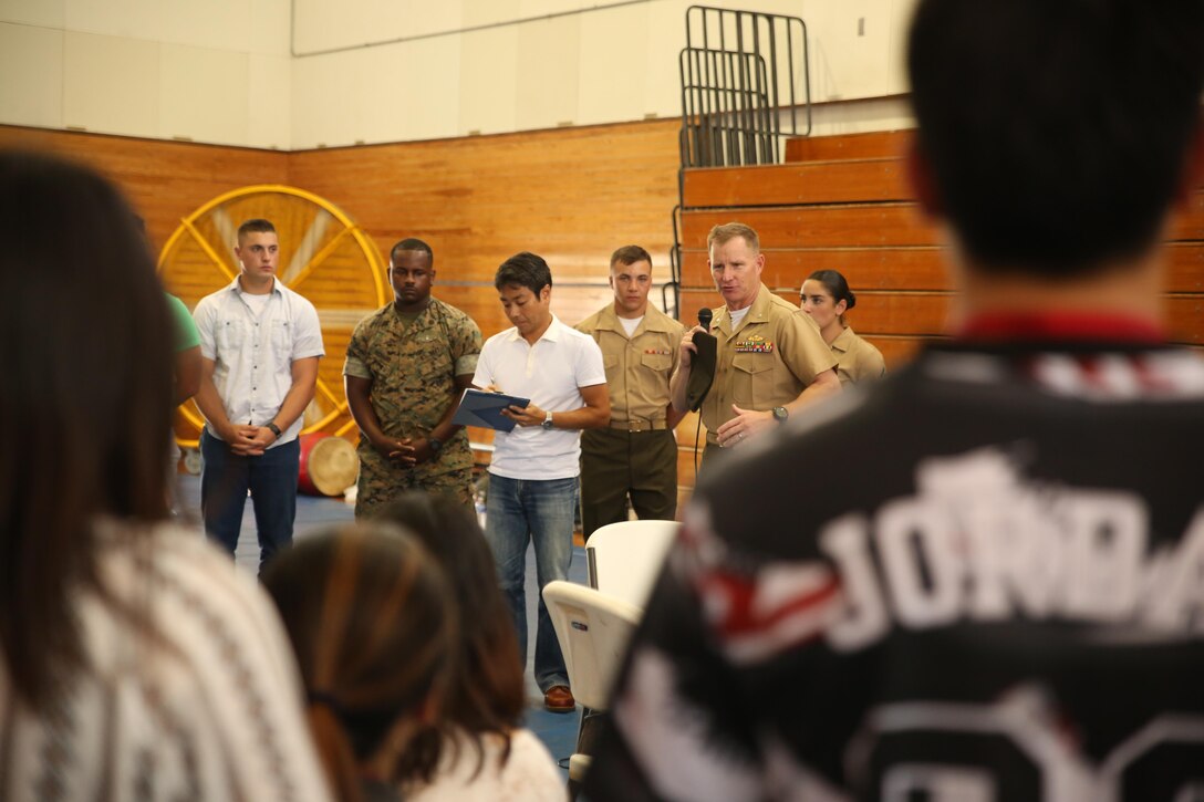 Lt. Col. Siebrand H. Niewenhous IV, commanding officer of Combat Logistics Battalion 31, 31st Marine Expeditionary Unit, greets Japanese students from Nikkei Business School in Okinawa City during the Okinawan-American Cultural Exchange Day, May 19, 2017, at House of Pain Fitness Center, on Camp Hansen, Okinawa, Japan. The Marines gave presentations about American culture and military operations to Japanese college students from Okinawa City and Naha, Okinawa. Marines with III MEF Headquarters Group hosted the cultural exchange day to strengthen bonds between the local community and service members, providing the two communities with the opportunity to converse and learn about each other’s culture. Niewenhous, a native of Pacific Grove, California, is a graduate of California State University. (U.S. Marine Corps photo by Sgt. Tiffany Edwards)