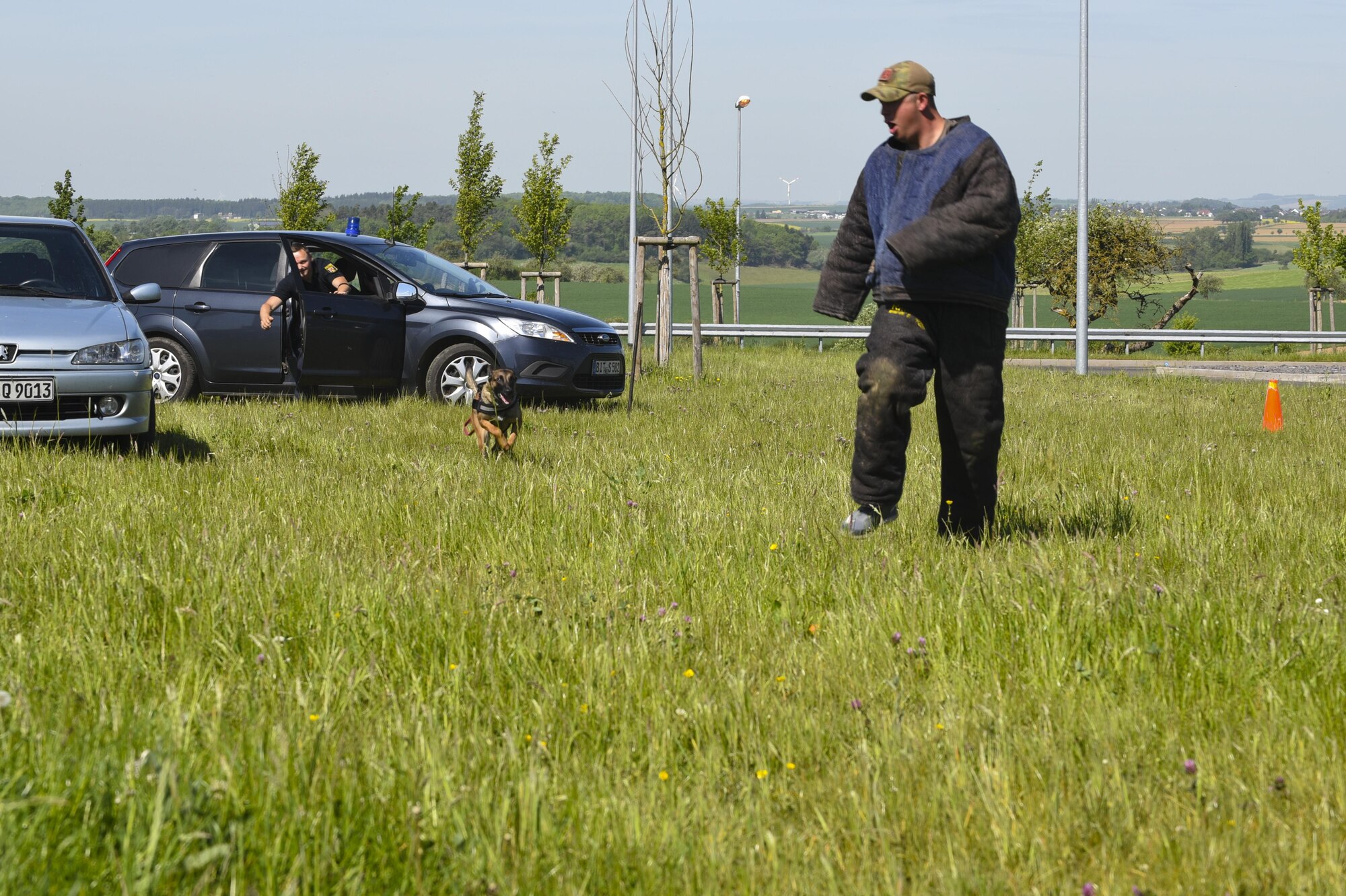 U.S. Air Force Staff Sgt. Tyler Catey, 52nd Security Forces Squadron military working dog trainer and Luxembourg Policemen, demonstrate working dog take-down techniques to Spangdahlem Elementary School students at Spangdahlem Air Base, Germany, May 16, 2017. This event was part of U.S. National Police Week, which recognizes the men, women and their canine companions who wear the badge. (U.S. Air Force photo by Senior Airman Dawn M. Weber)