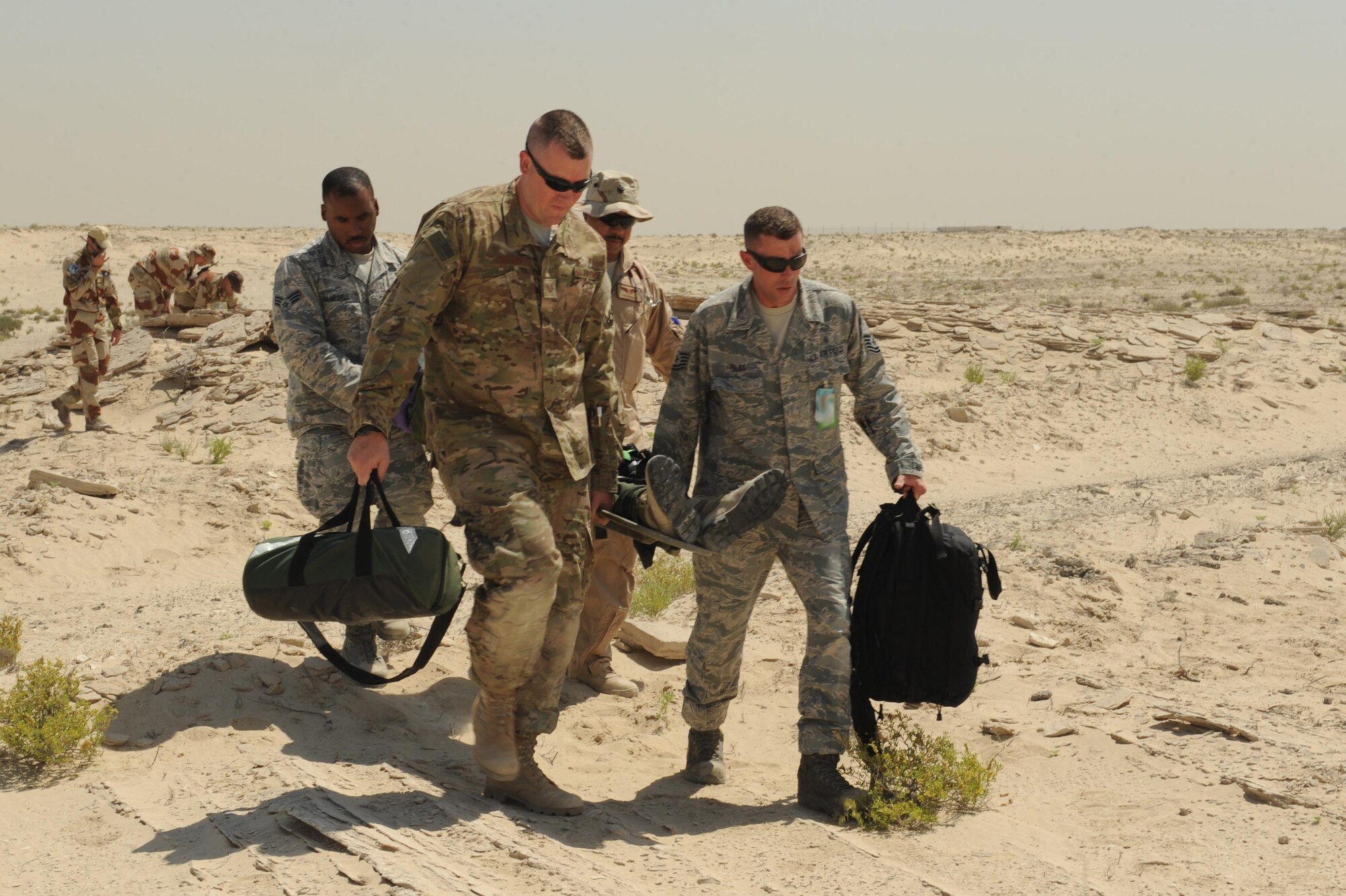 Members of the 380th Expeditionary Medical Group medical operations flight transport a patient from the scene of a crash exercise at an undisclosed location in Southwest Asia, May 16, 2017. Coalition members worked together to respond to two separate exercise sites to test how they would respond in the event of an aircraft mishap. [Faces of French personnel have been obscured at the request of l'Armée de l'air.] (U.S. Air Force photo by Staff Sgt. Marjorie A. Bowlden)