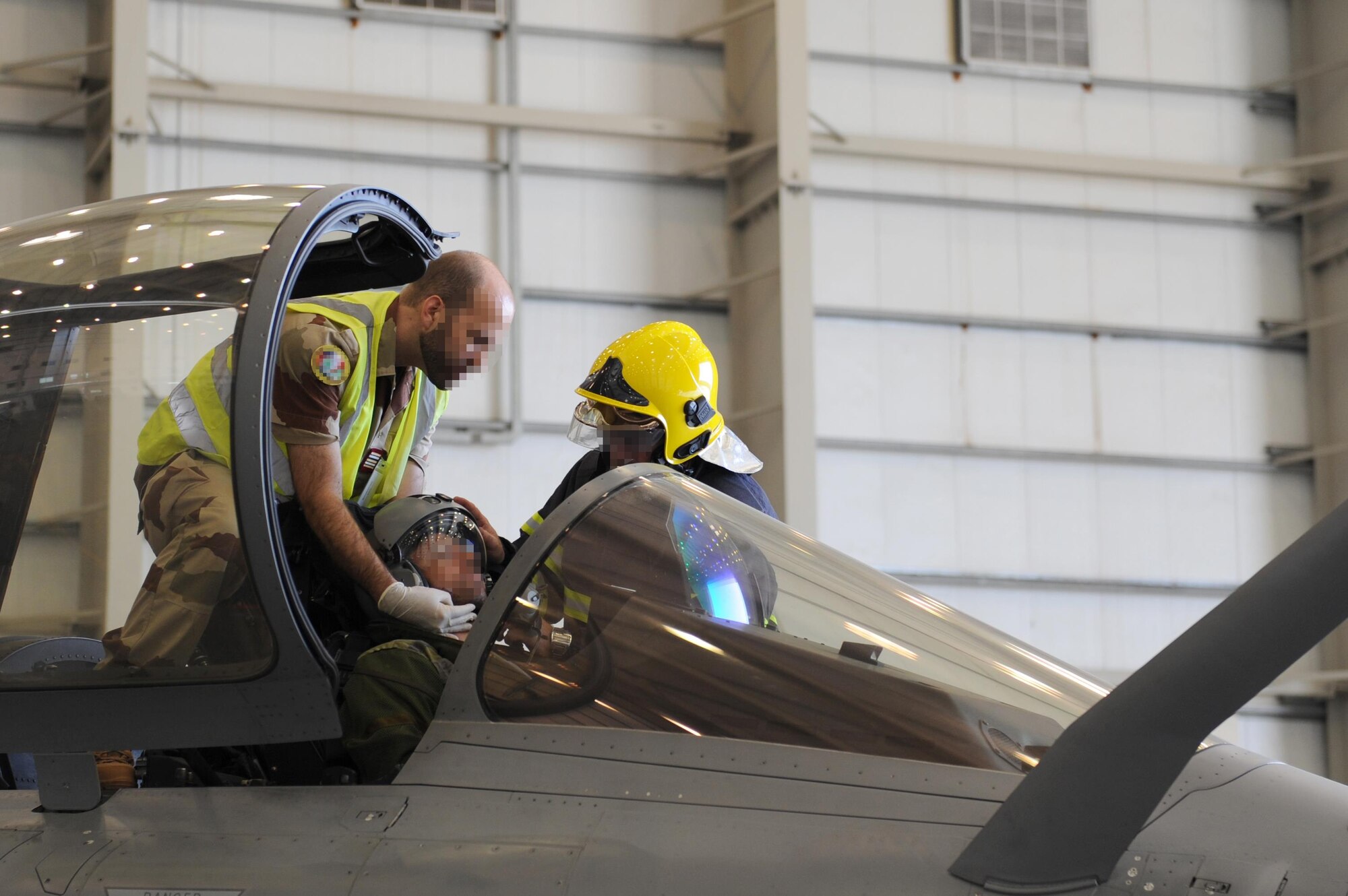 A French medic and firefighter begin a trauma assessment on a French pilot during a Coalition crash exercise at an undisclosed location in Southwest Asia, May 16, 2017. This exercise was the first of its kind at this location and opened avenues for closer working relationships between Coalition partner services. [Faces of French personnel have been obscured at the request of l'Armée de l'air.] (U.S. Air Force photo by Staff Sgt. Marjorie A. Bowlden)