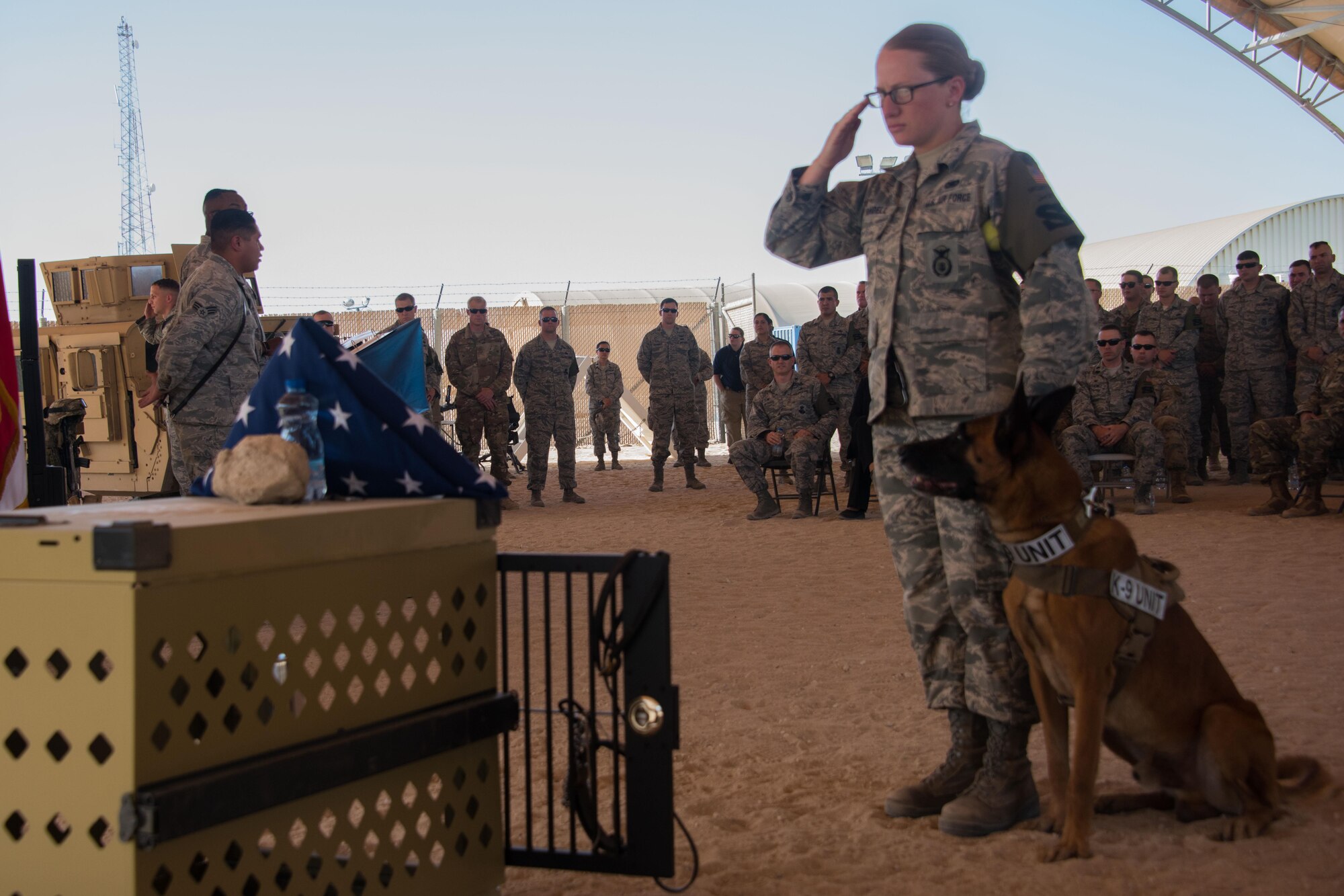 Senior Airman Sara Yandell, a military working dog handler with the 386th Expeditionary Security Forces Squadron, salutes the kennel display at the opening ceremony for 2017 Police Week at an undisclosed location in Southwest Asia, May 14, 2017. The empty kennel has long been a symbol of solace in the military working dog community. The kennel is empty; he is gone but not forgotten. (U.S. Air Force photo/TSgt Jonathan Hehnly)