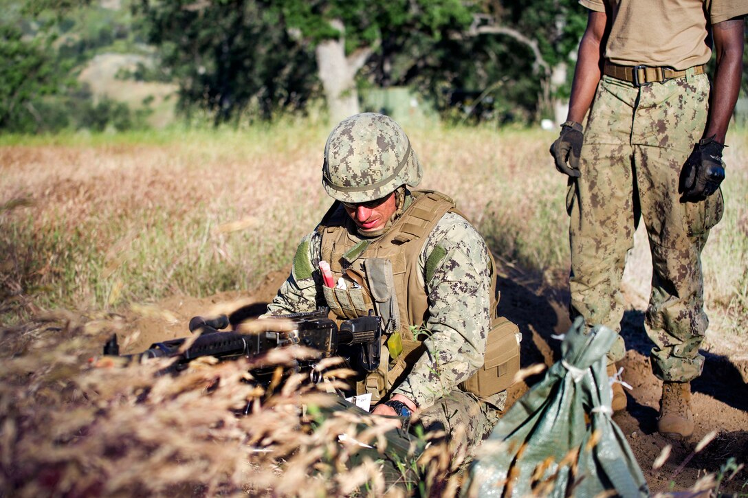 Navy Petty Officer 3rd Class John Melton positions his machine gun during a field training exercise at Fort Hunter Liggett, Calif., May 12, 2017. Melton is an equipment operator assigned to Naval Mobile Construction Battalion 4. Navy photo by Petty Officer 2nd Class Jasmine Flores