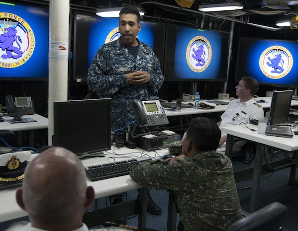 Lt. Cmdr. Edward Cruzmatos discusses the capabilities of Afloat Forward Staging Base (Interim) USS Ponce (AFSB(I)-15) with participants of the International Maritime Exercise (IMX) 2017. IMX is a command post exercise and includes more than 20 partner nations to promote interoperability, increase readiness in all facets of defensive maritime warfare and demonstrate resolve in maintaining regional security and stability and protecting the free flow of commerce. (U.S. Navy photo by Mass Communication Specialist 1st Class Grant P. Ammon)