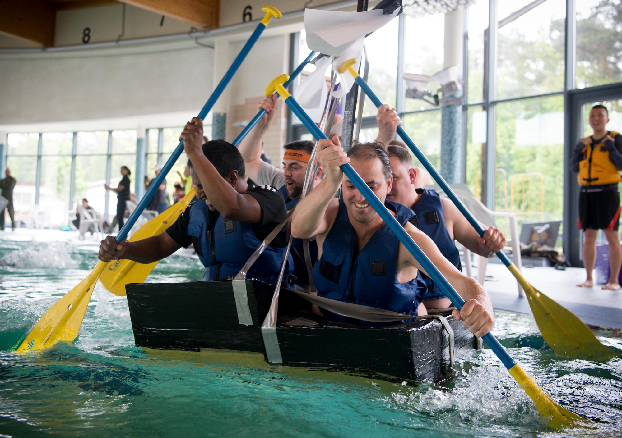 The 86th Medical Squadron Landstuhl Regional Medical Center's Battle of the Battleships team, the "Purple Parrots," race their homemade "battleship" at the Ramstein Aquatic Center on Ramstein Air Base, May 19, 2017. Teams of Airmen assigned to various squadrons designed and built "battleships" out of cardboard and duct tape, which they used to compete for aquatic superiority. The 86th Force Support Squadron Ramstein Aquatic Center hosts Battle of the Battleships annually to foster community and morale in the Kaiserslautern Military Community. (U.S. Air Force photo by Senior Airman Elizabeth Baker)
